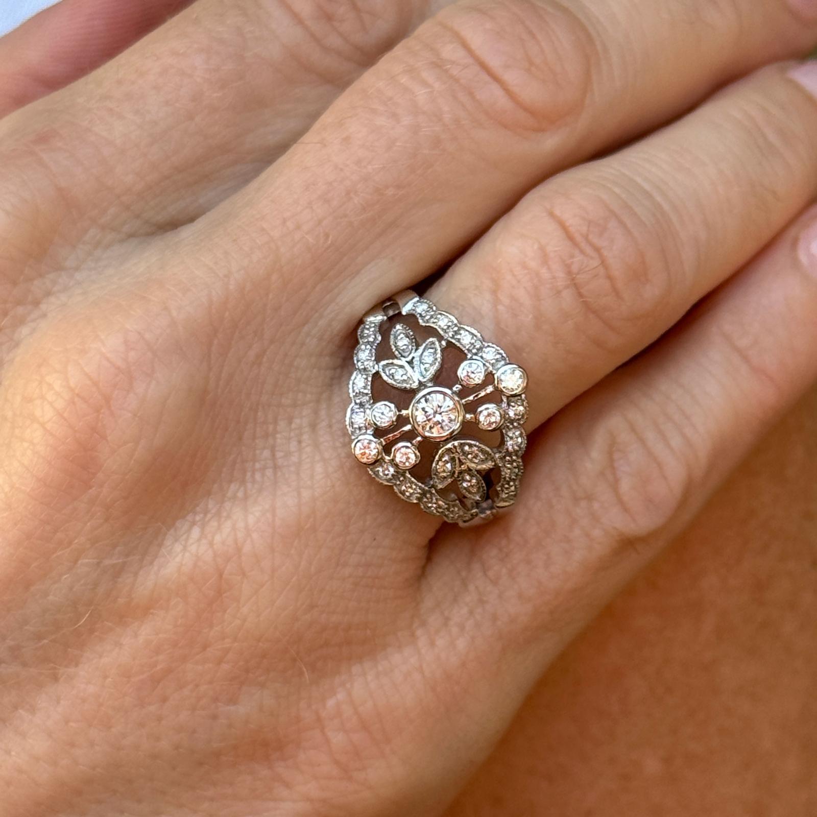 1960's diamond filigree estate ring handcrafted in 14 karat white gold. The ring features 29 round brilliant cut diamonds weighing approximately .50 carat total weight and graded E-F color and VS clarity. The ring measures 16.5mm in width (on top),