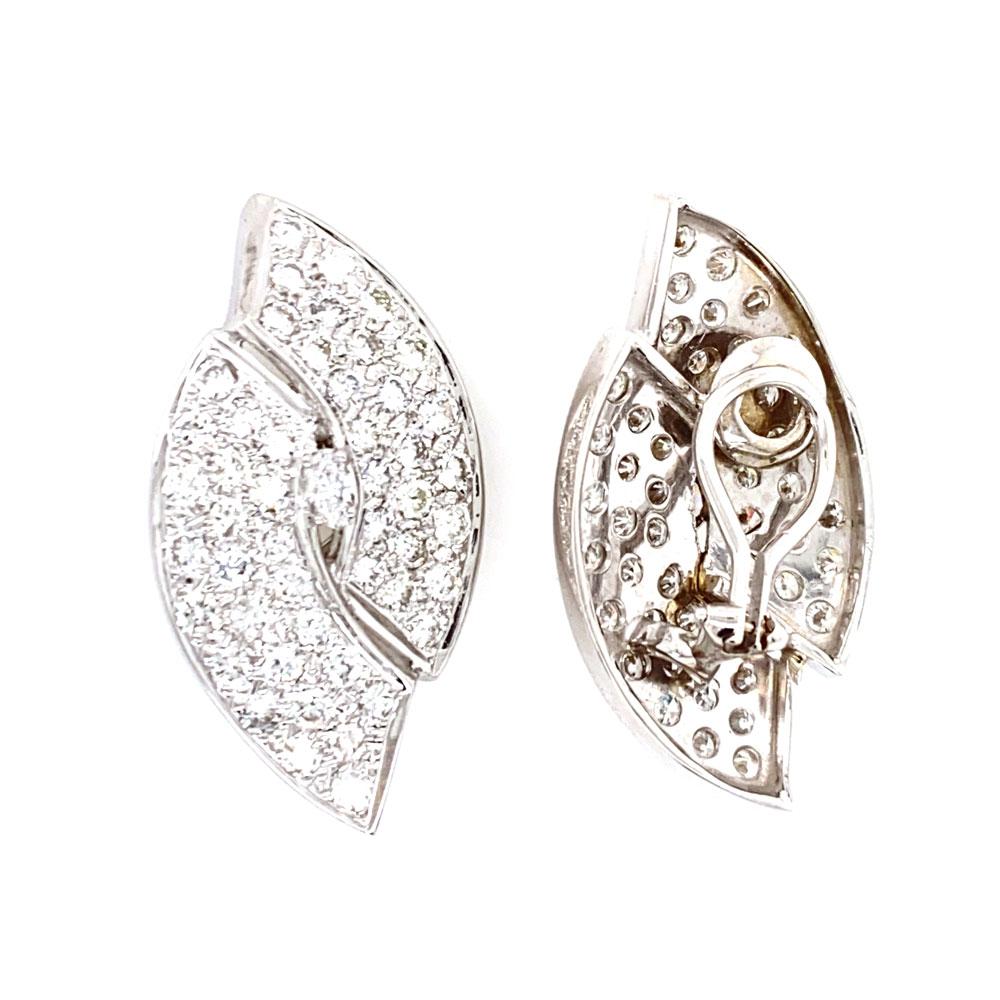 1960's diamond ear clips feature round brilliant and marquise cut white diamonds. The diamonds weigh approximately 5.50 carat total weight and are graded G-H color and SI clarity. The earrings are the shape of an offset oval, and have a beautiful