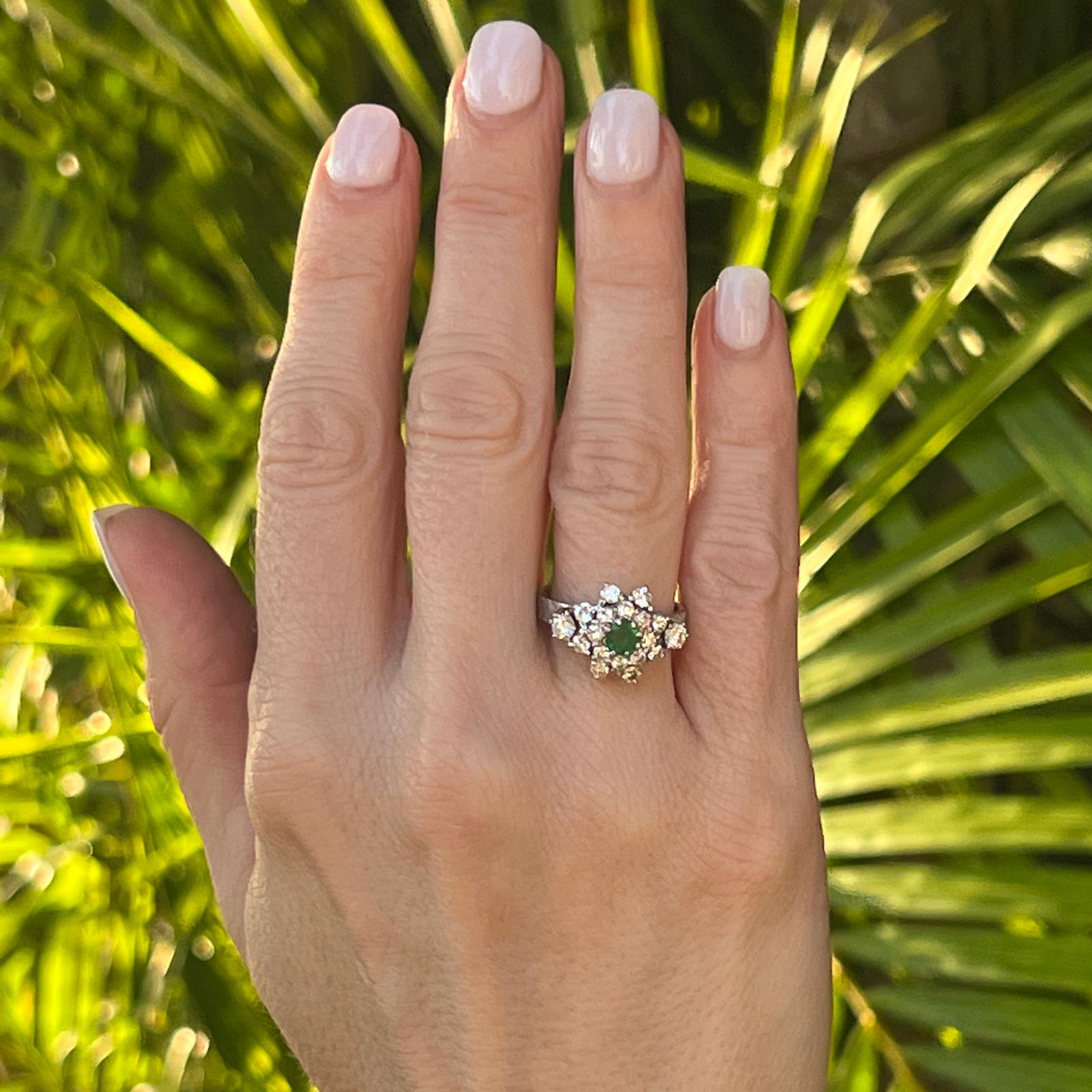 Vintage-Cocktailring mit Diamanten und Smaragden, gefertigt aus Platin. Der Ring hat einen Smaragd von ca. 0,40 Karat in der Mitte und 18 runde Diamanten im Brillantschliff von ca. 1,00 Karat Gesamtgewicht. Die Diamanten sind von der Farbe G-H und