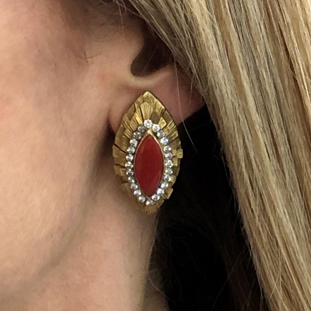 Diamond red coral earrings circa 1960. These elegant earrings are fashioned in textured 18 karat yellow gold and feature 1.68 carat total weight of round brilliant cut diamonds surrounding Italian red coral. The diamonds are graded G-H color and