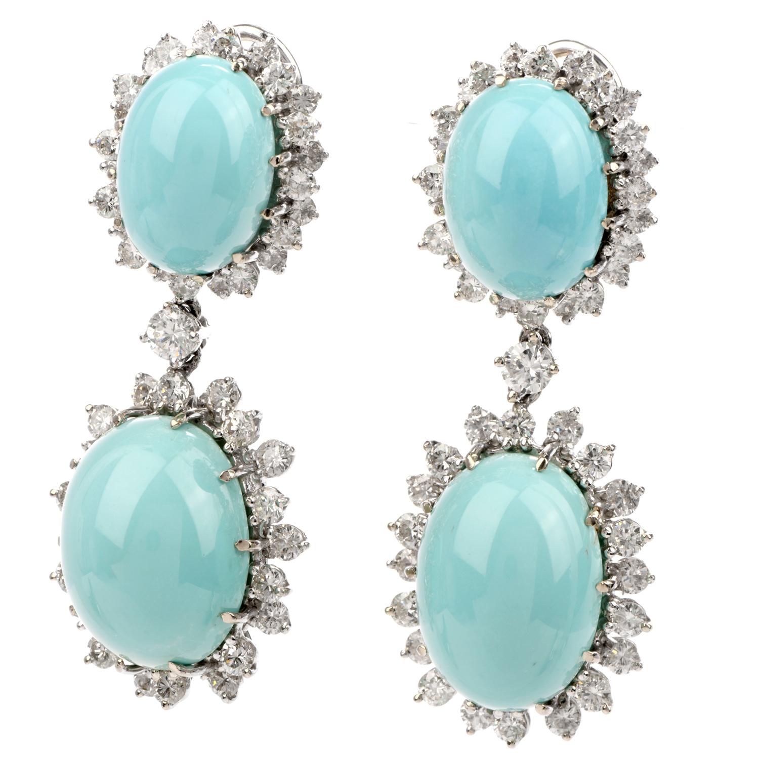 These stunning Vintage 1960's diamond and turquoise dangle earrings are crafted in 14-karat white gold, weighing 26.2 grams and measuring 1.75” long x 19mm wide. Exposing four prong-set oval shaped cabochon Persian turquoise of light teal color