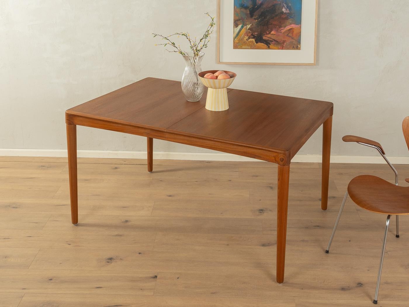 Seltener ausziehbarer Teak-Esstisch aus den 1960er Jahren von H.W. Klein für Bramin. Massives Gestell und furnierte Tischplatte mit Massivholzkante. Die Verlängerungsplatte kann unter der Tischplatte verstaut werden.

Qualitätsmerkmale:

vollendetes