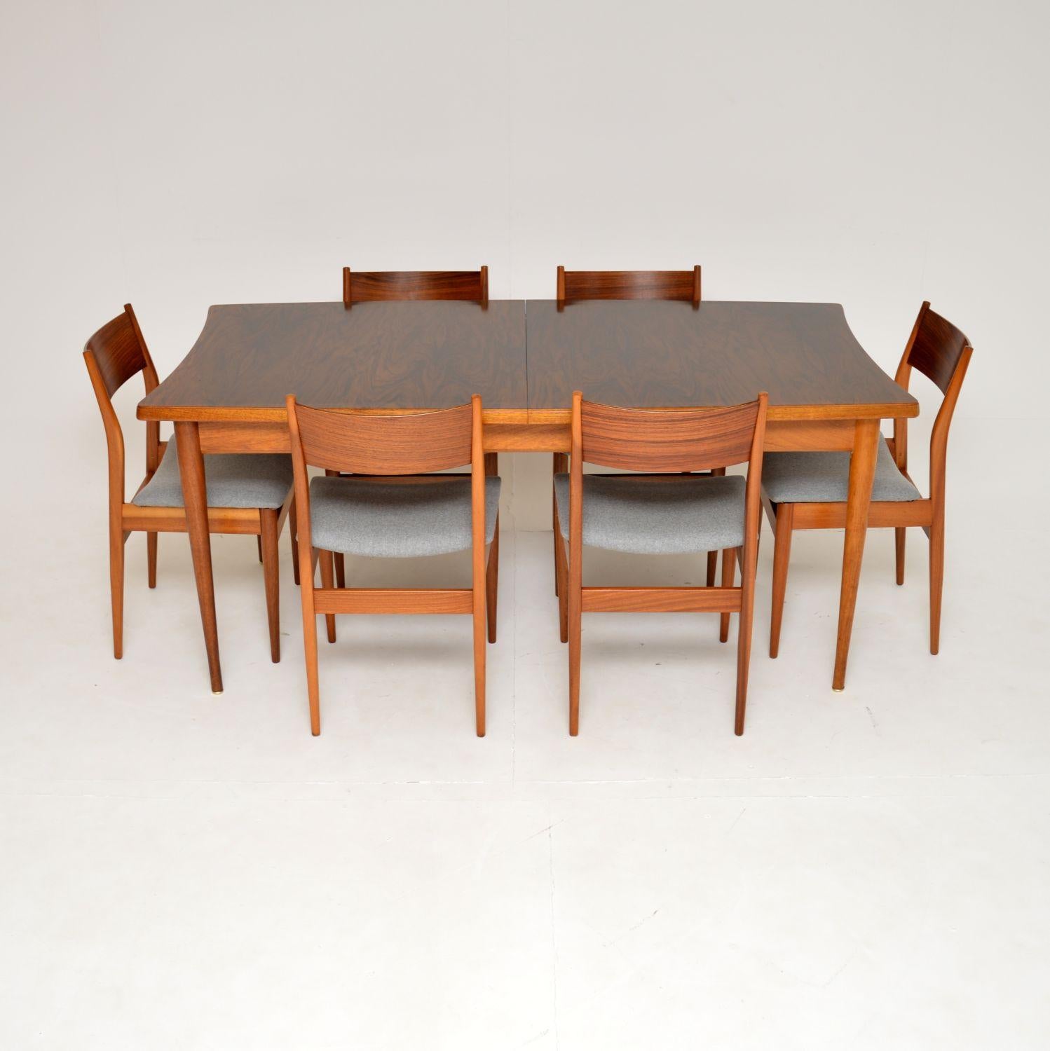 A superb vintage dining table and chairs, made in England by Uniflex and dating from the 1960’s.

This set is beautifully designed and is of amazing quality. The frames of the chairs and tables are solid wood, the backs of the chairs and table top