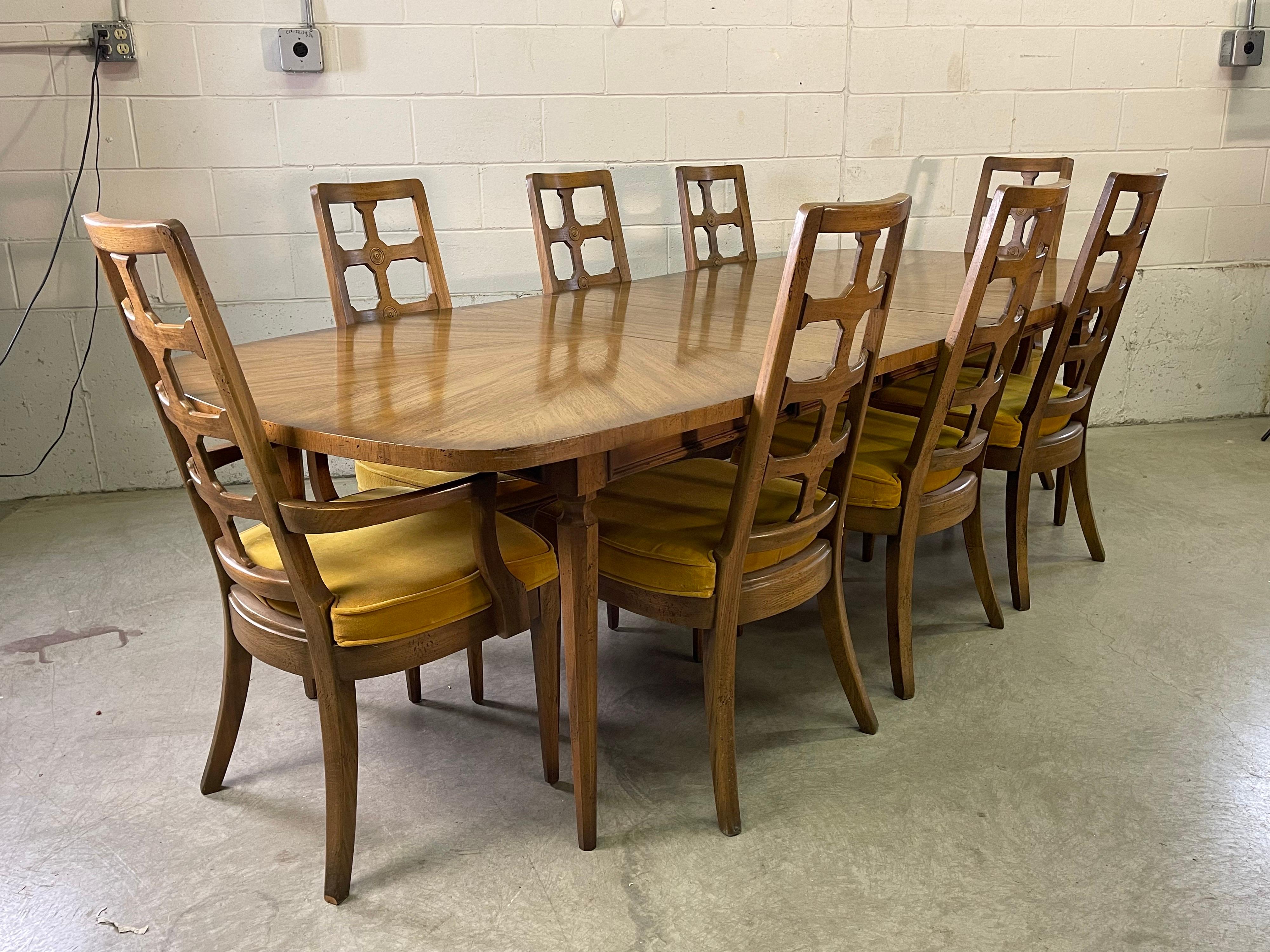 Vintage 1960s dining table with 8 chairs. The table has 3 additional boards to expand. The table top has a chevron design with black accents all over the table and chairs. The chairs come with 2 captain chairs and 6 regular chairs. Table and chairs