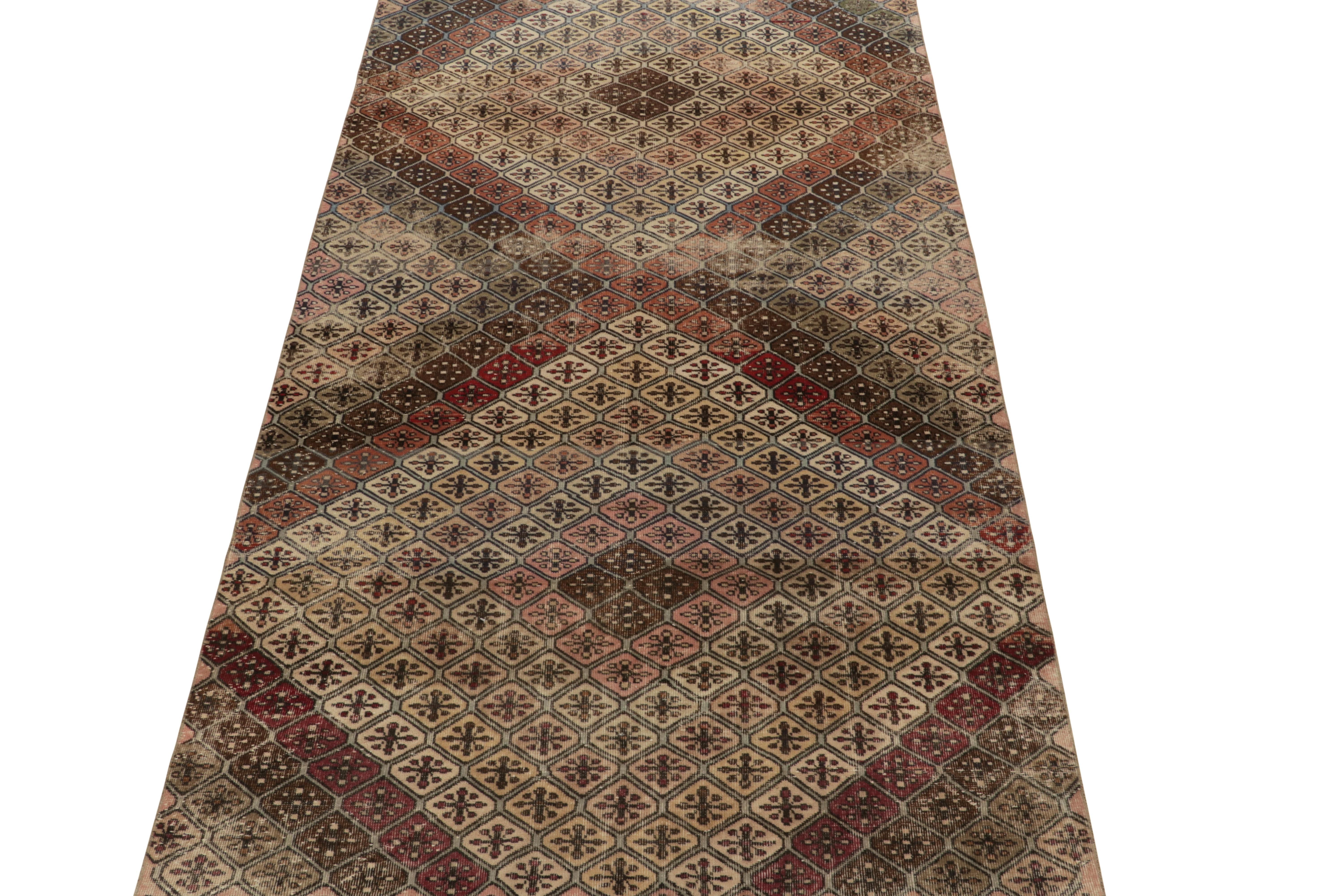 Un tapis vintage 6x11 issu des œuvres d'un audacieux designer turc multidisciplinaire, parmi les derniers à rejoindre la collection Pasha du milieu du siècle de Rug & Kilim. 

Le magnifique jeu de beige-brun, de rose, de noir et de rouge donne un
