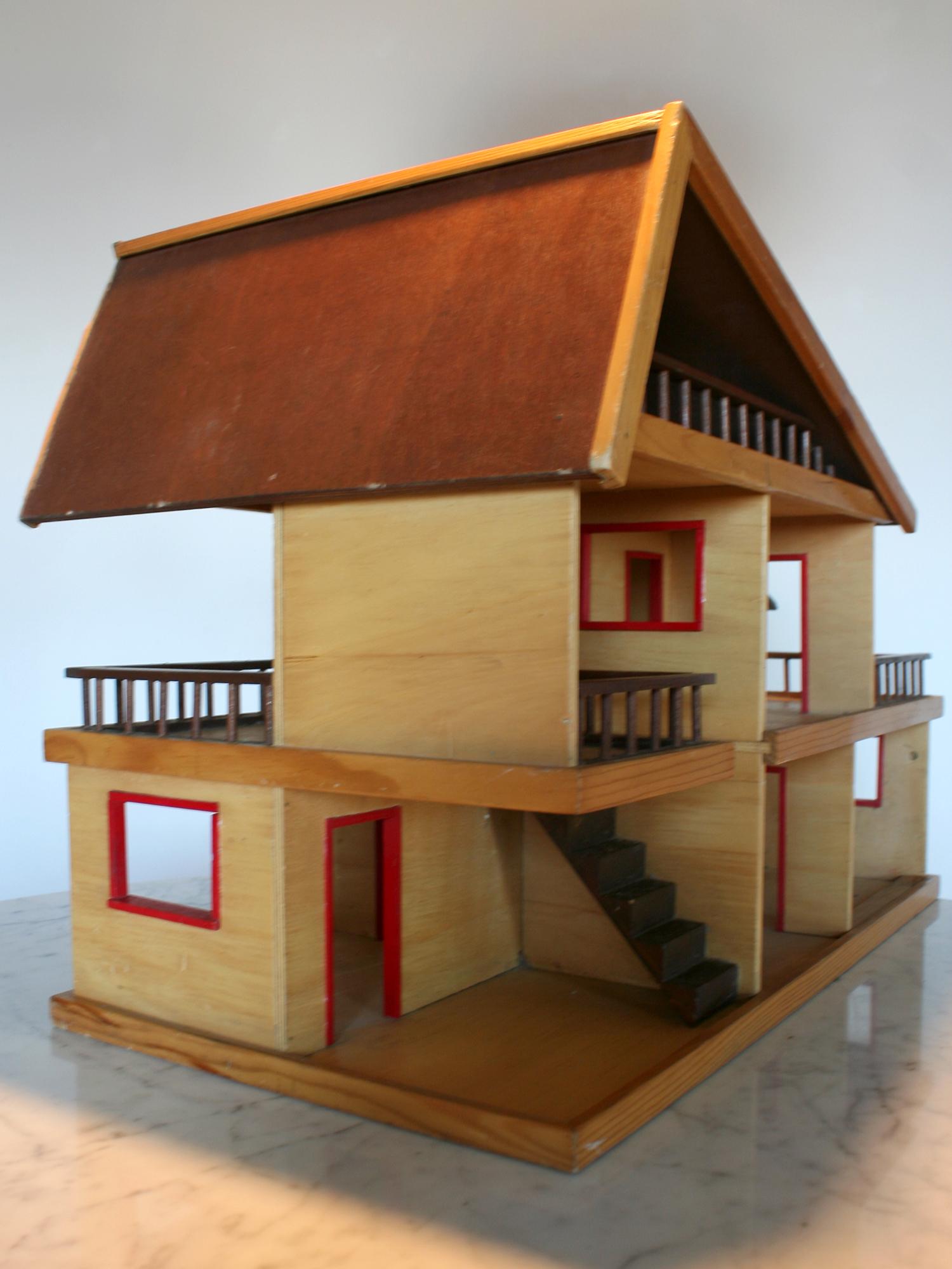A wooden dollhouse from the 1960s. Chalet-shaped, its rooms are open.
Good overall condition. A wooden edge and a plinth are missing.