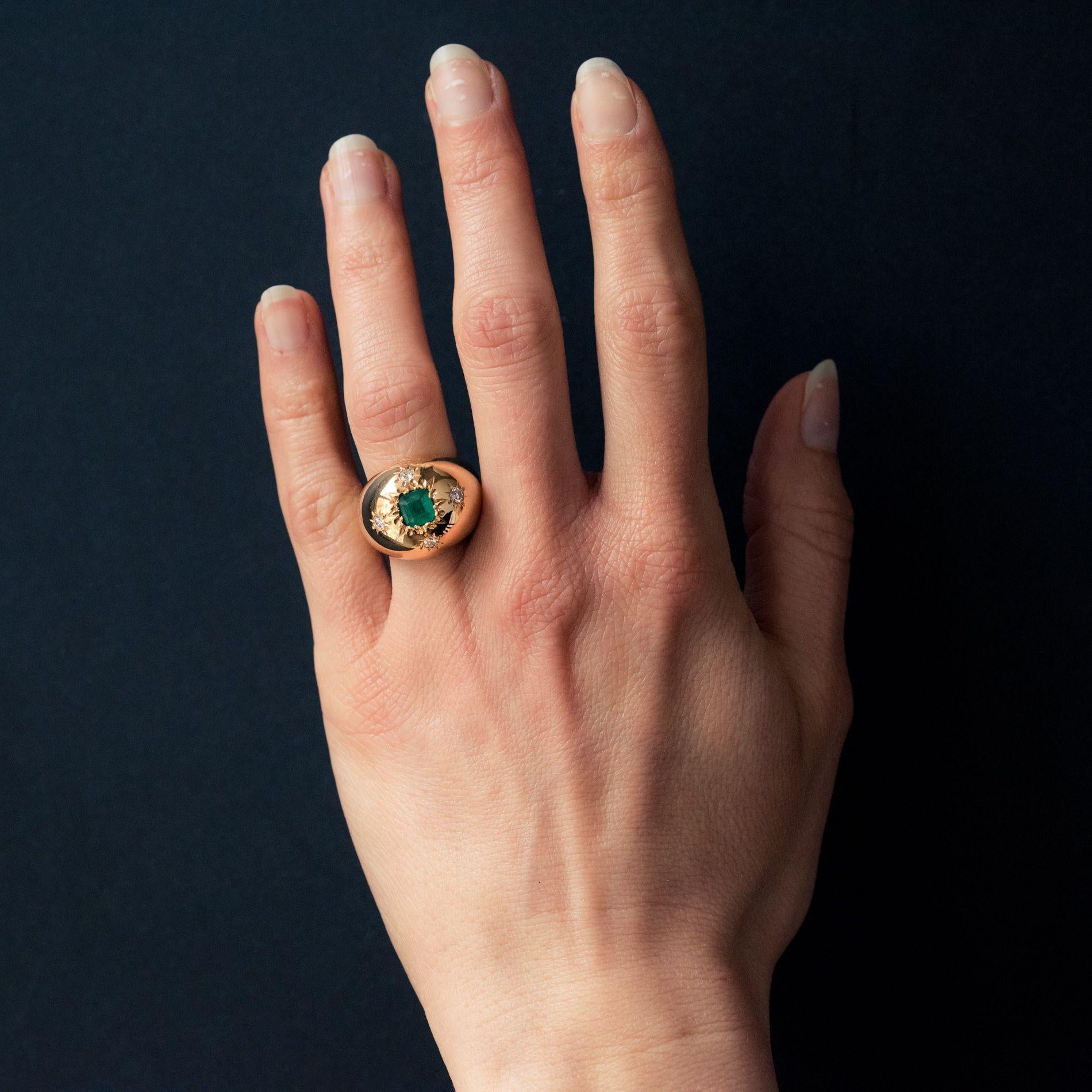 Ring in 18 carat yellow gold, owl hallmark. 
A large domed antique ring with an emerald cut emerald featuring modern  brilliant cut diamonds at each corner. 
Total weight of the emerald: approximately 0.85 carat 
Total weight of diamonds: 0.20 carat