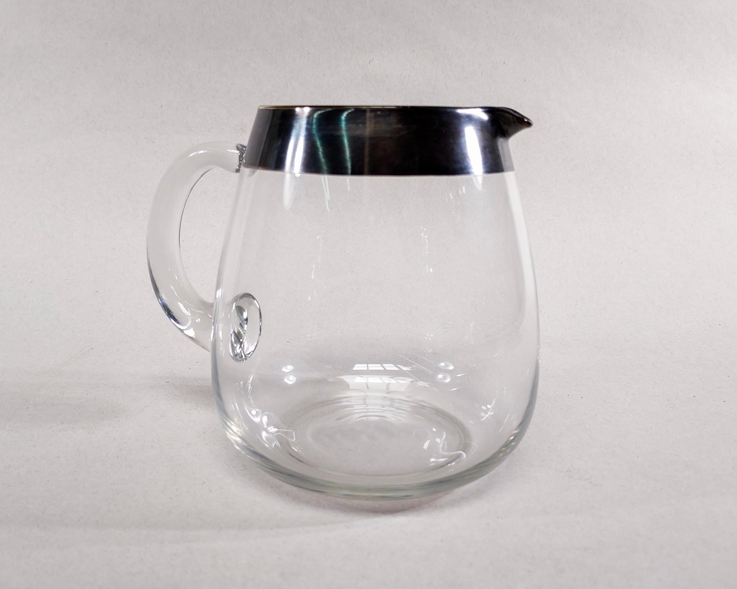Original 1960s Dorothy Thorpe hand blown glass pitcher with iced lip spout. Iconic thick sterling silver band around the rim. Overall great vintage condition, natural darkened patina on silver, some light wear on rim as shown in photos.

6-3/4
