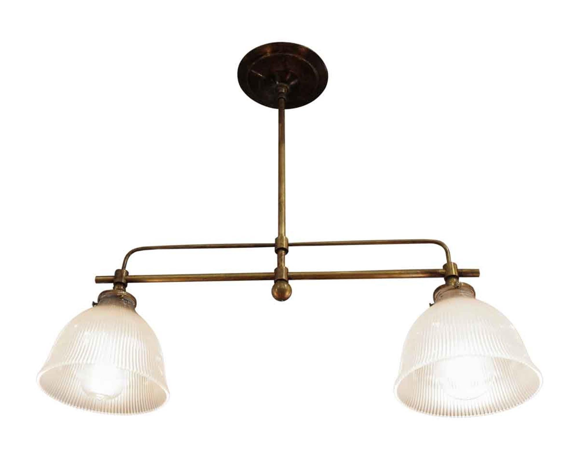 Custom brass double down light fixture with two Holophane glass shades from the 1960s. This can be seen at our 5 East 16th St location on Union Square in Manhattan.