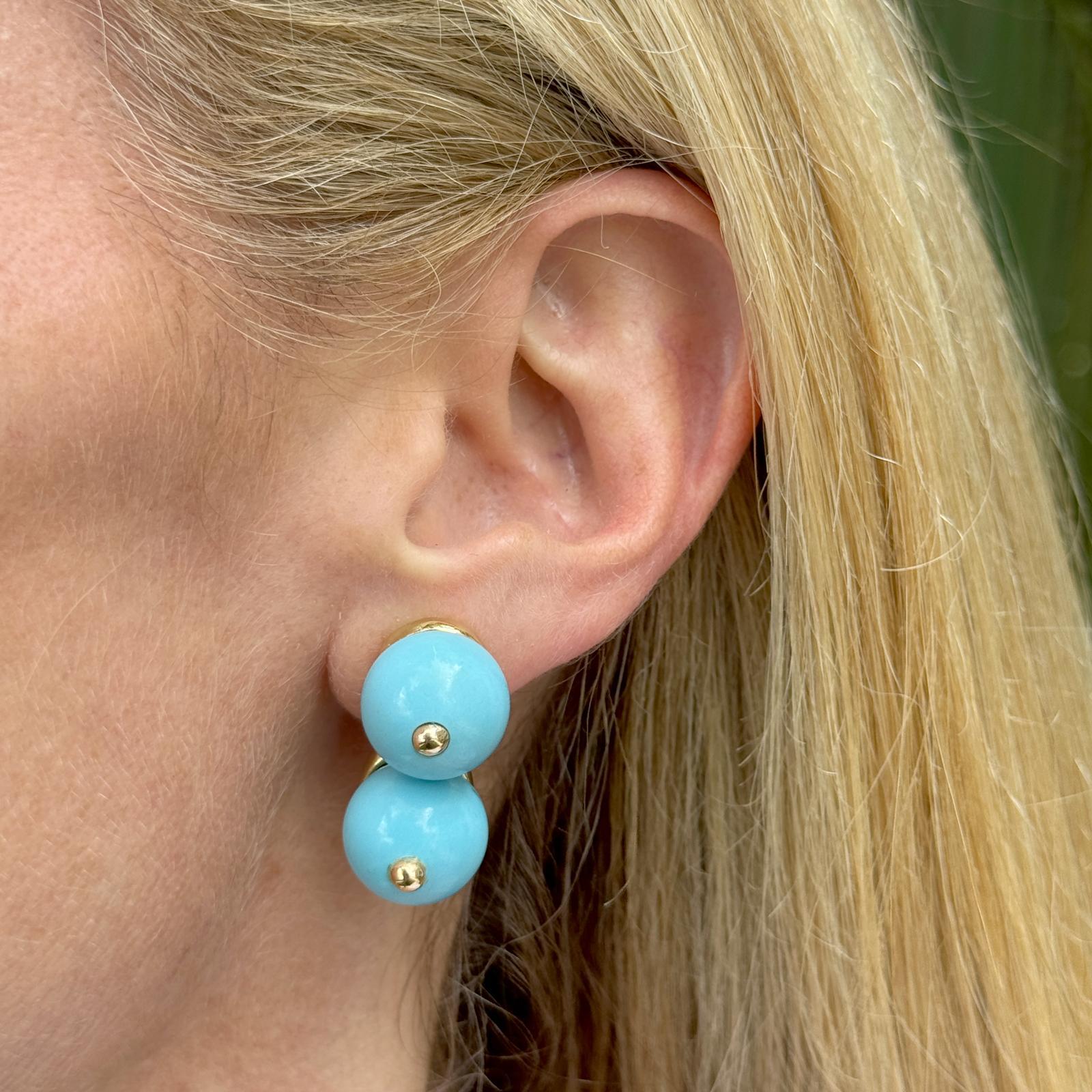 The Double Turquoise 18 Karat Yellow Gold Ear-Clip Earrings are a striking blend of classic elegance and vibrant color. Each earring features two captivating turquoise stones measuring 14mm, set in luxurious 18 karat yellow gold, highlighting their