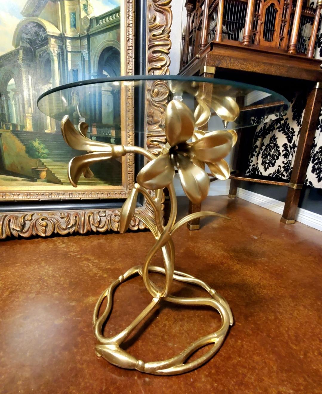 Art Nouveau and Arthur Court inspired cast aluminum side table, with an aged gilt finish. Base is comprised of three flowering lilies with intertwined stems in a figure eight pattern, finishing with a circular three sectioned base of stems and