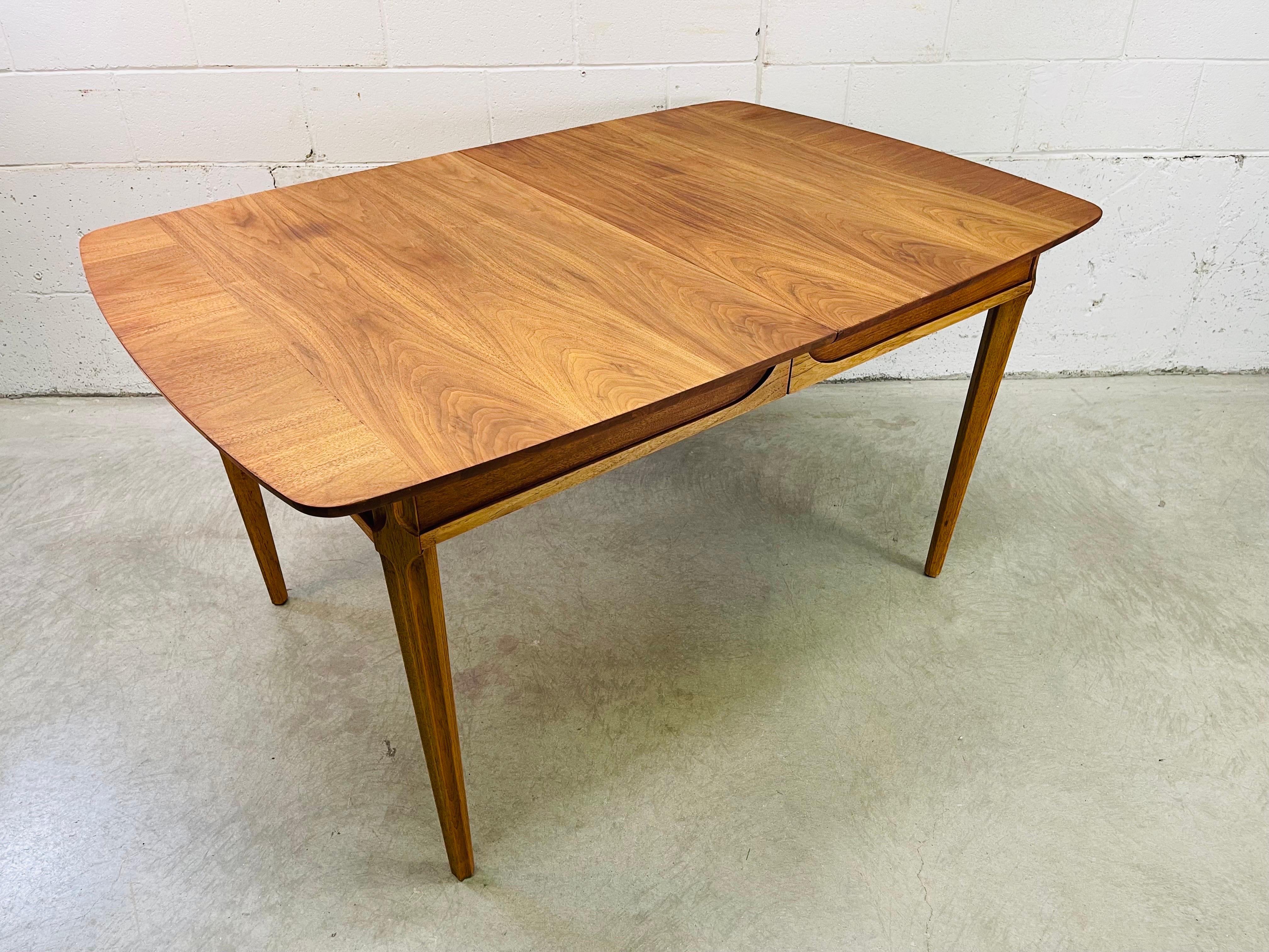 Vintage 1960s walnut wood dining table by Drexel Furniture in the Tempo line. The table has a beautiful walnut grain with tapered legs. No additional boards. Marked underneath.