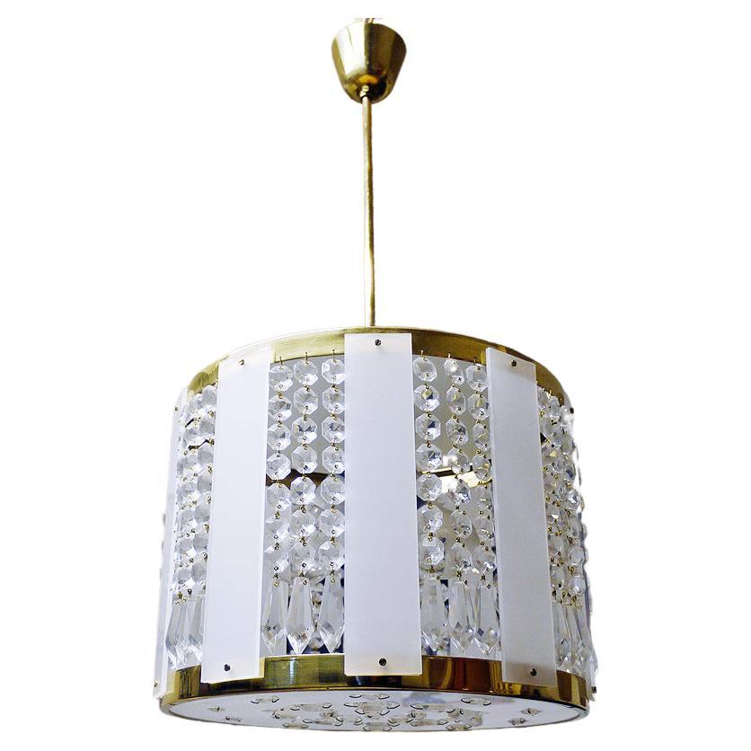 Elegant drum shaped chandelier with faceted crystals and lucite panels on a golden brass frame. Chandelier illuminates beautifully and offers a lot of light. Gem from the time. With this light you make a clear statement in your interior design. A