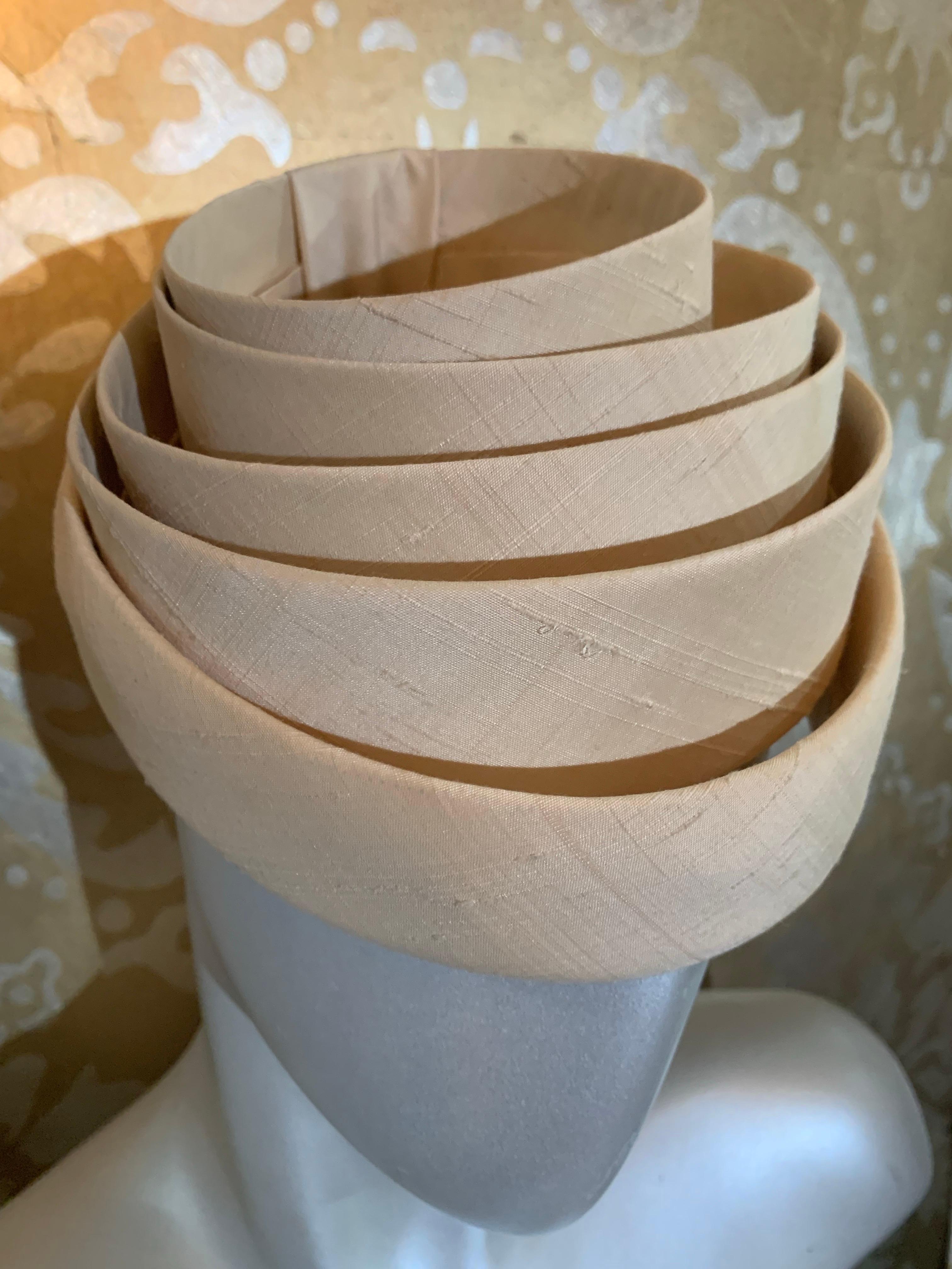 Cappello modernista in seta ecru degli anni '60 con anelli graduati di seta strutturata e fiocco sul retro:  Un cappello Luci Junior in seta dupionica ecru, favolosamente elegante e insolito, destinato alla corona della testa con i suoi anelli a