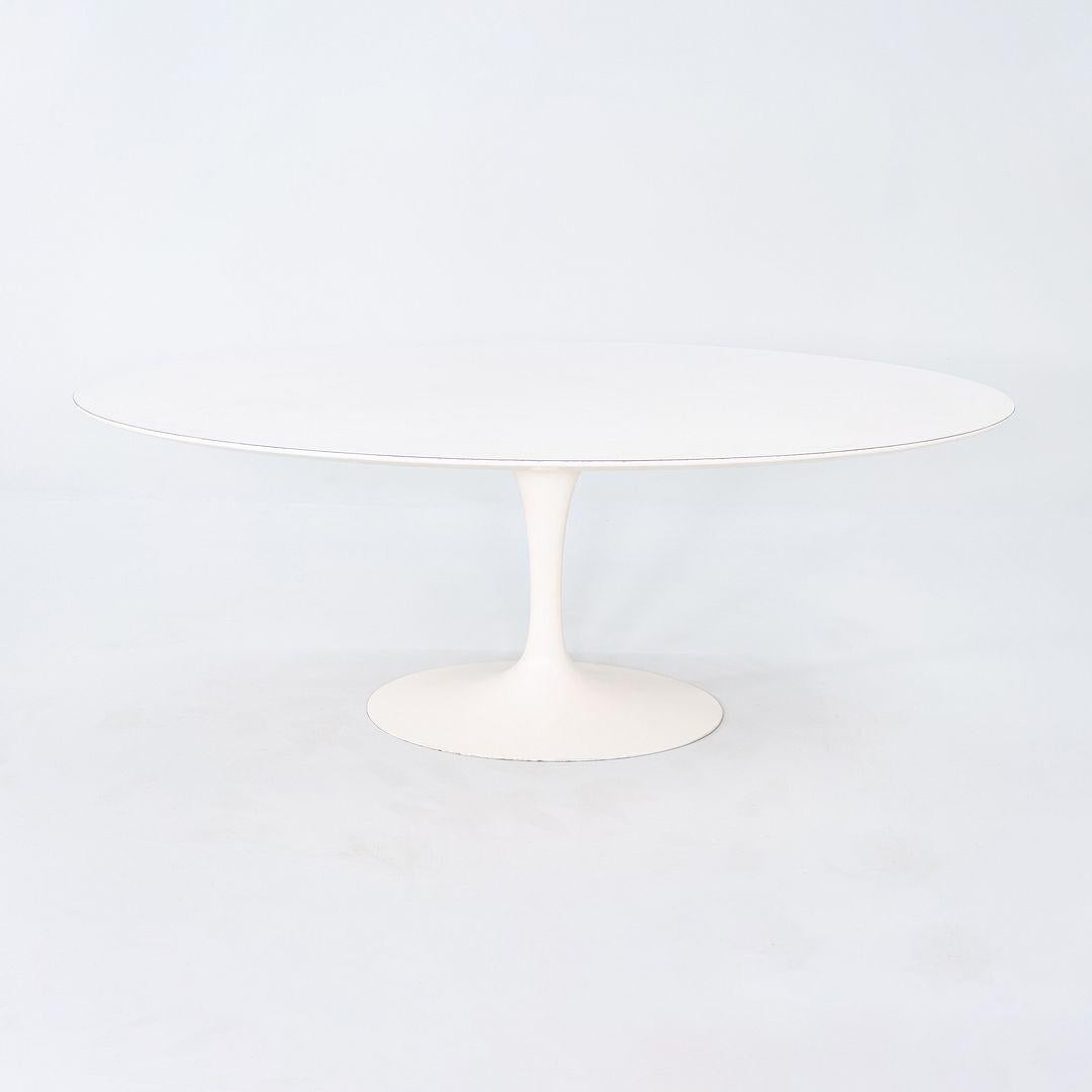 This is a Tulip Dining Table, originally designed in 1956 by Eero Saarinen for Knoll. This particular piece was produced in the USA in the 1960s. The base is formed of cast iron which is coated in a white satin finish. Its top is made of smooth