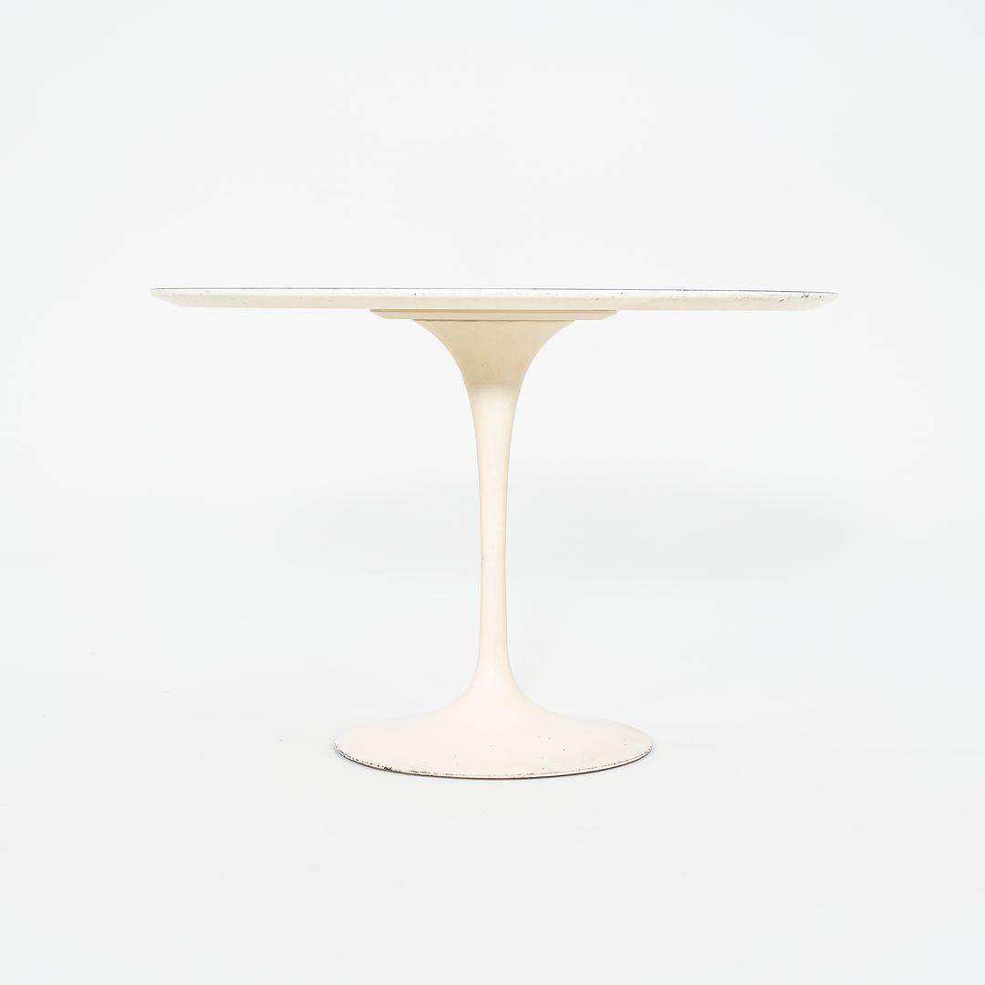 Il s'agit d'une table de salle à manger à piédestal, conçue à l'origine en 1956 par Eero Saarinen pour Knoll. Cette pièce particulière a été produite aux États-Unis dans les années 1960. La base est formée de fonte qui est revêtue d'une finition