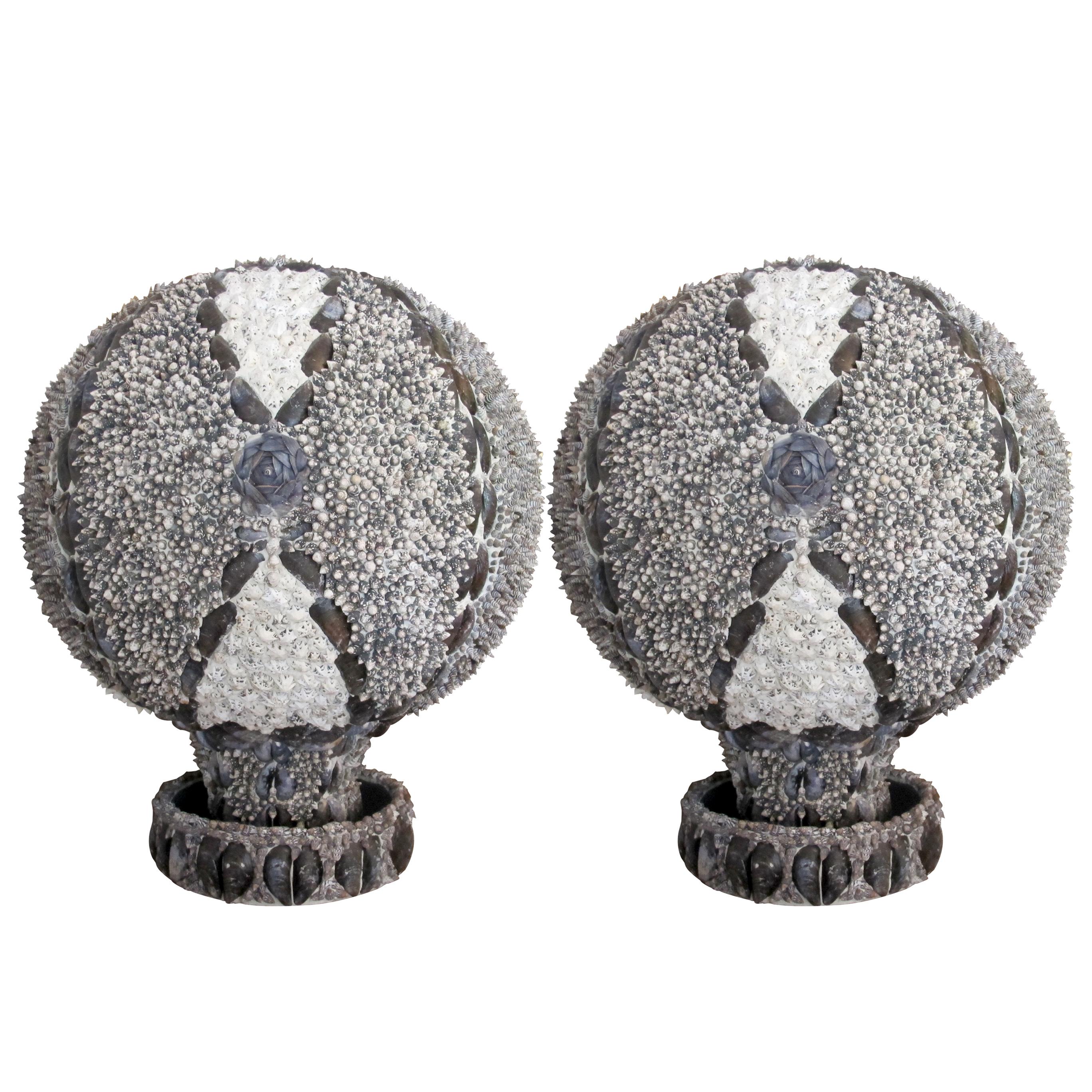 This pair of large decorative 1960s oak spheres have been embellished by an independent English artist. They are intricately adorned with a diverse arrangement of seashells. Each sphere features a harmonious combination of textures and patterns,