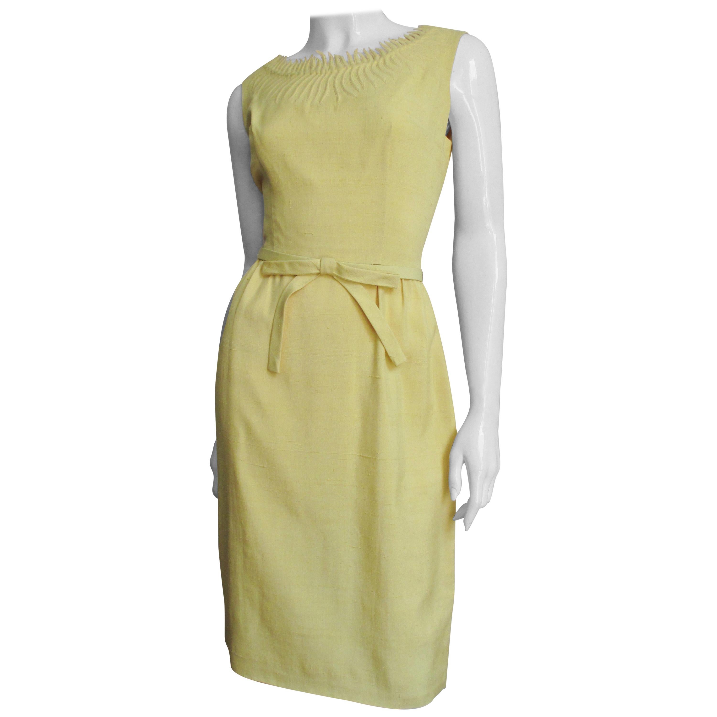 A beautiful yellow linen dress and off white cashmere cardigan sweater set. The sleeveless semi fitted dress has amazing detailed embroidery and cut work in the form of rays emanating from around the neckline. This intricate work is repeated around