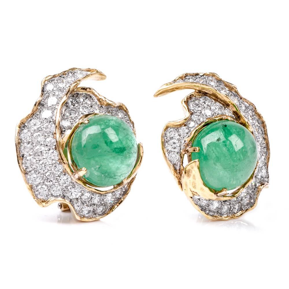 These classically elegant estate earrings wit emerald cabochons and diamonds are crafted in 18 karat yellow gold, weigh together 20.9 grams and measure 27 mm x 22 mm. The earrings are designed with stylized floral motif, they are adorned with 2
