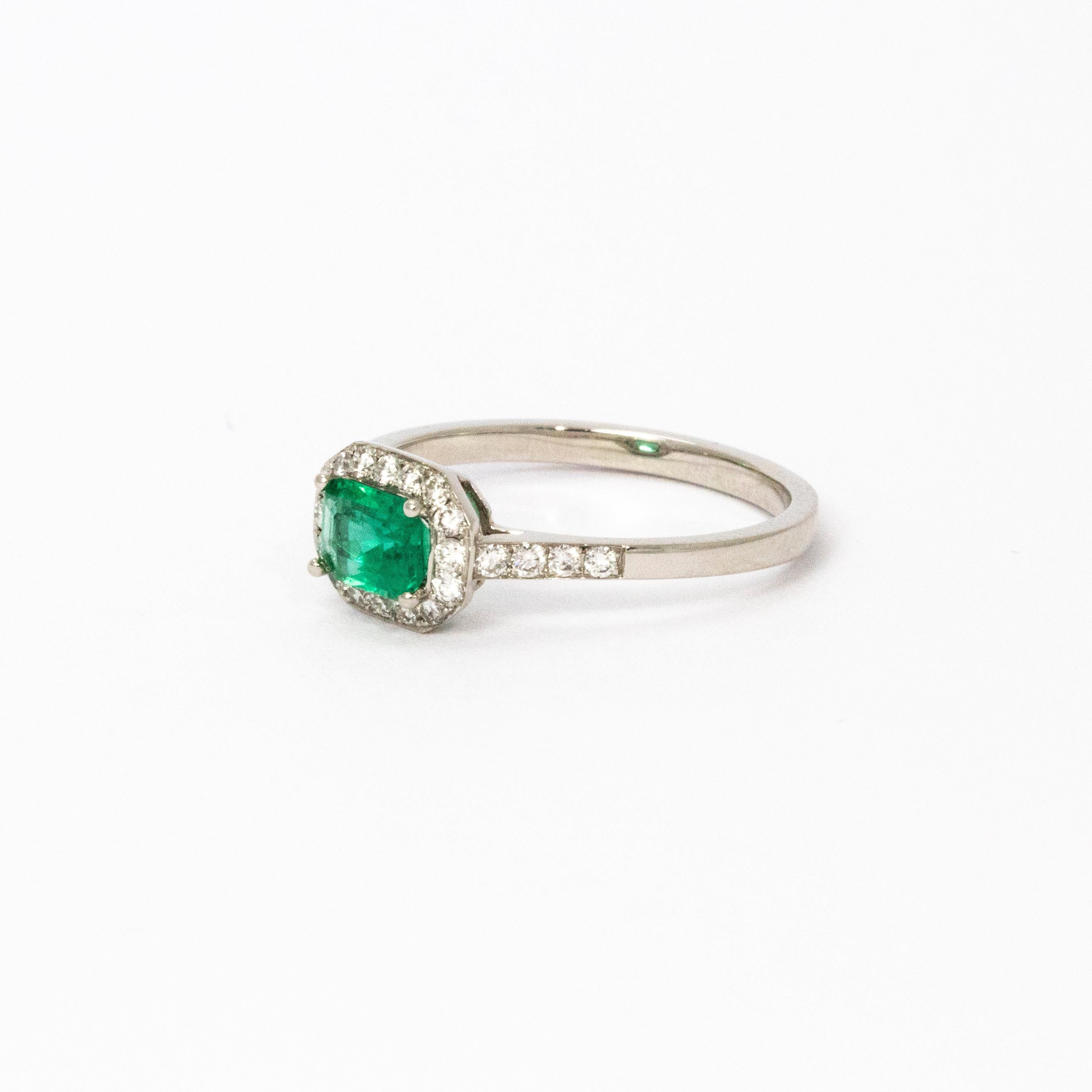 A beautiful 1960s ring. Centrally set is a certified 0.63 carat green emerald with impeccable colour. Around the central stone is a wonderful halo of bright brilliant cut diamonds which extend across the shoulders. Total diamond weight certified 45