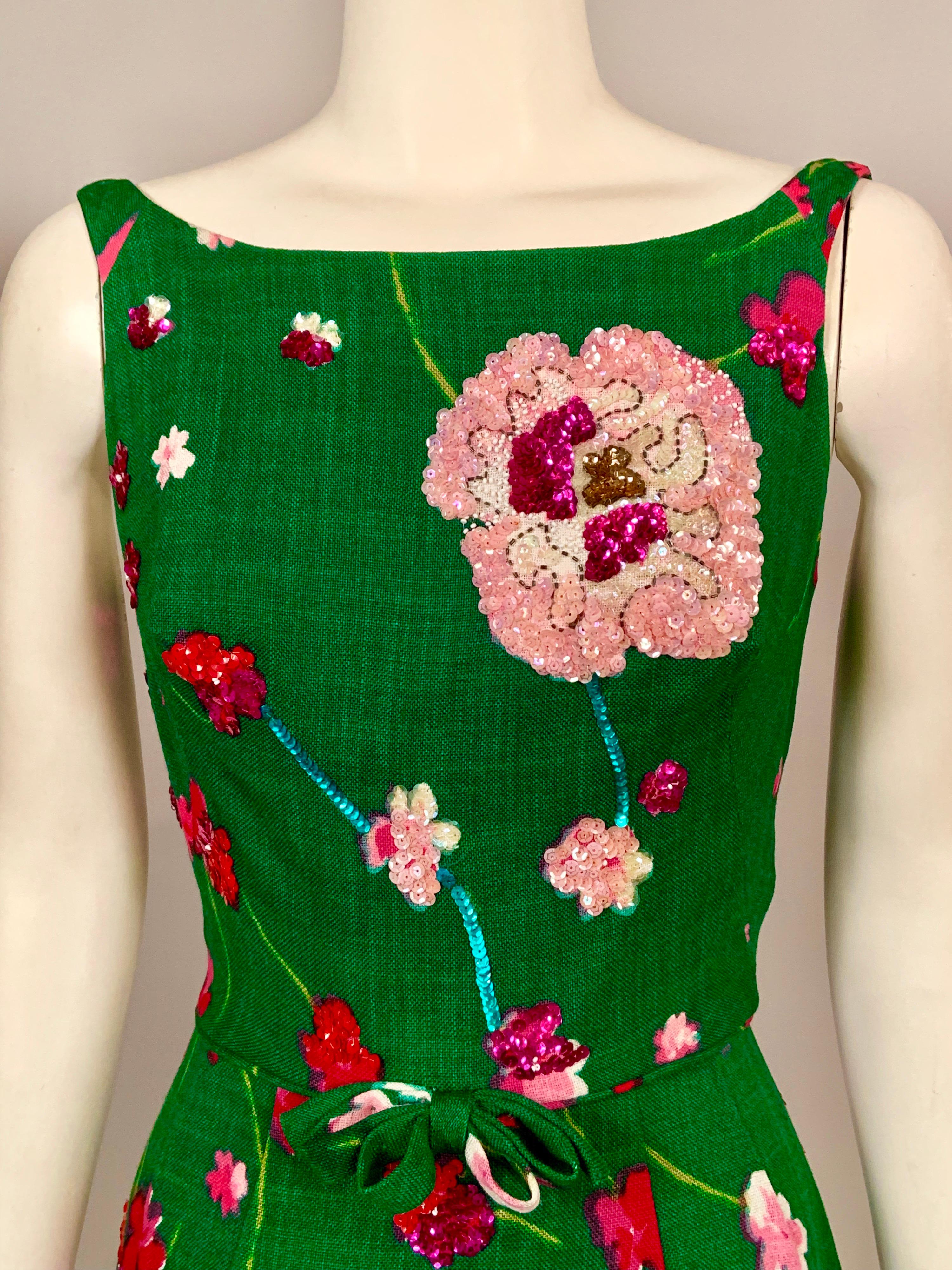 This emerald green linen dress has a wonderful floral print in many shades of pink, from almost white to red. Many of the flowers on the bodice and skirt are covered with sequins and beads to match the print, turning it into a great summer party or