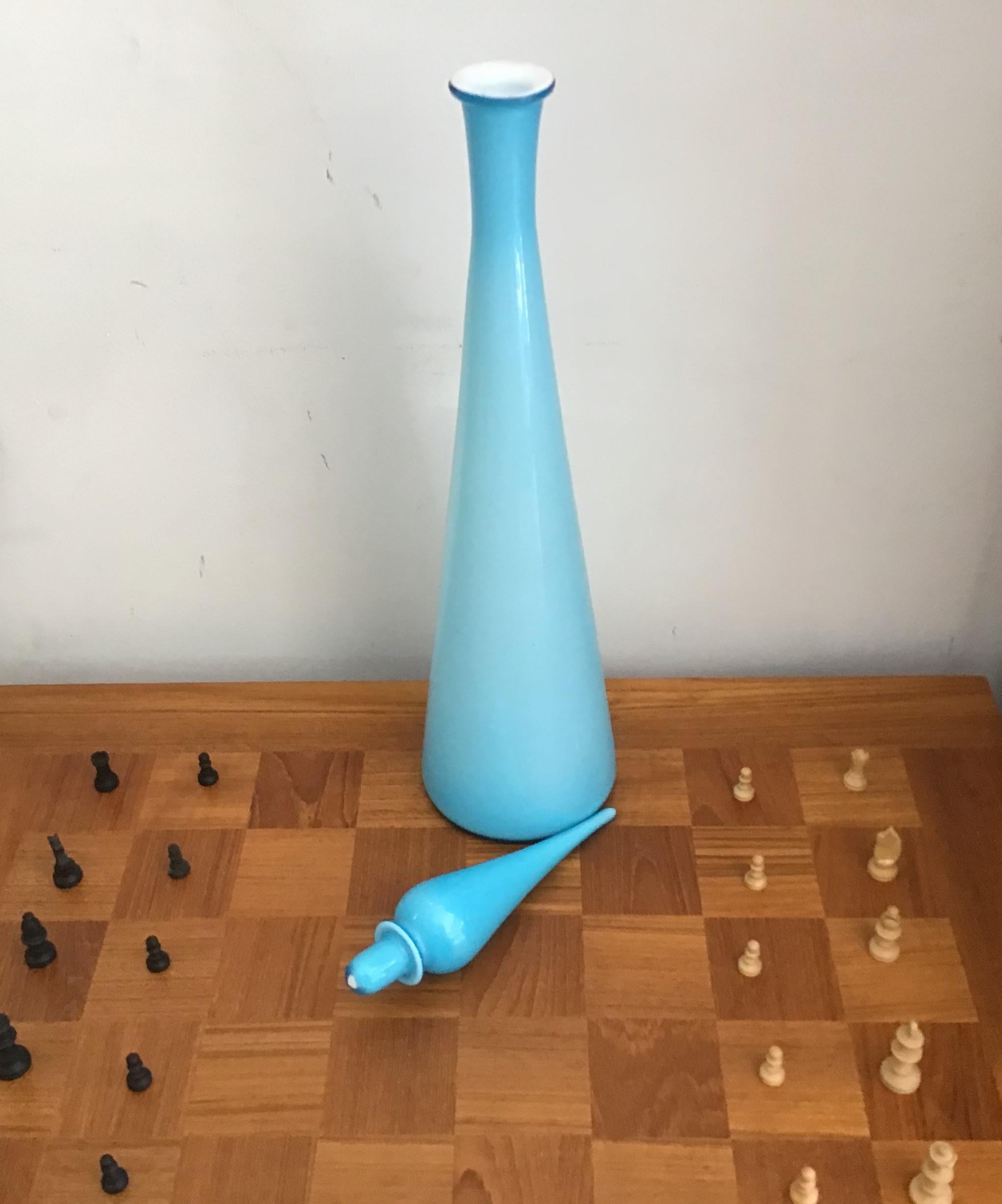 A fantastic extra large pale turquoise (or pale cyan or bright baby blue) colored Empoli genie bottle/decanter. Unusually it's cased with white inside so it's not transparent. 

Vintage, circa 1960s, most likely from Empoli, Italy.
Dimensions