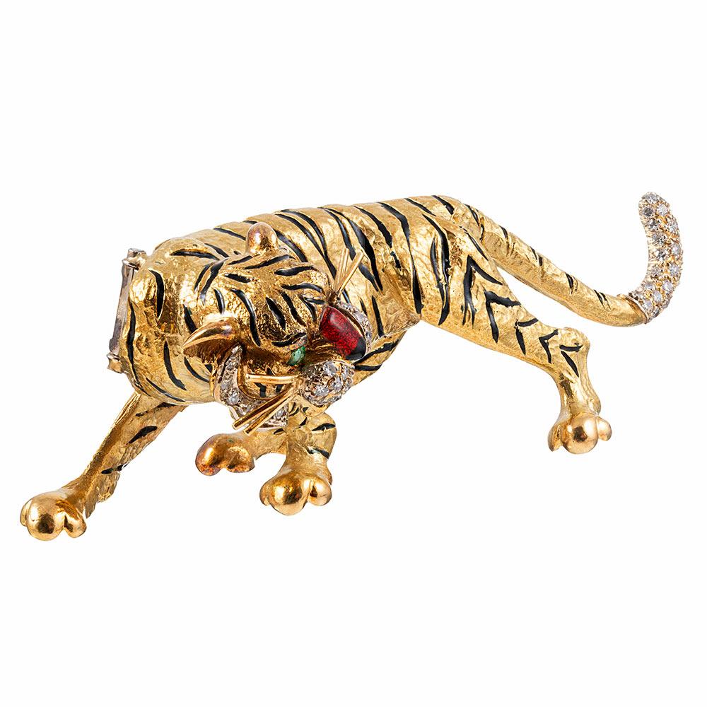 This charming creature is substantial in design and execution, measuring 3.5 inches long and 1.25 inches tall. Rendered in 18 karat yellow gold, the piece is decorated with black enamel stripes, red enamel tongue & nose, emerald eyes and