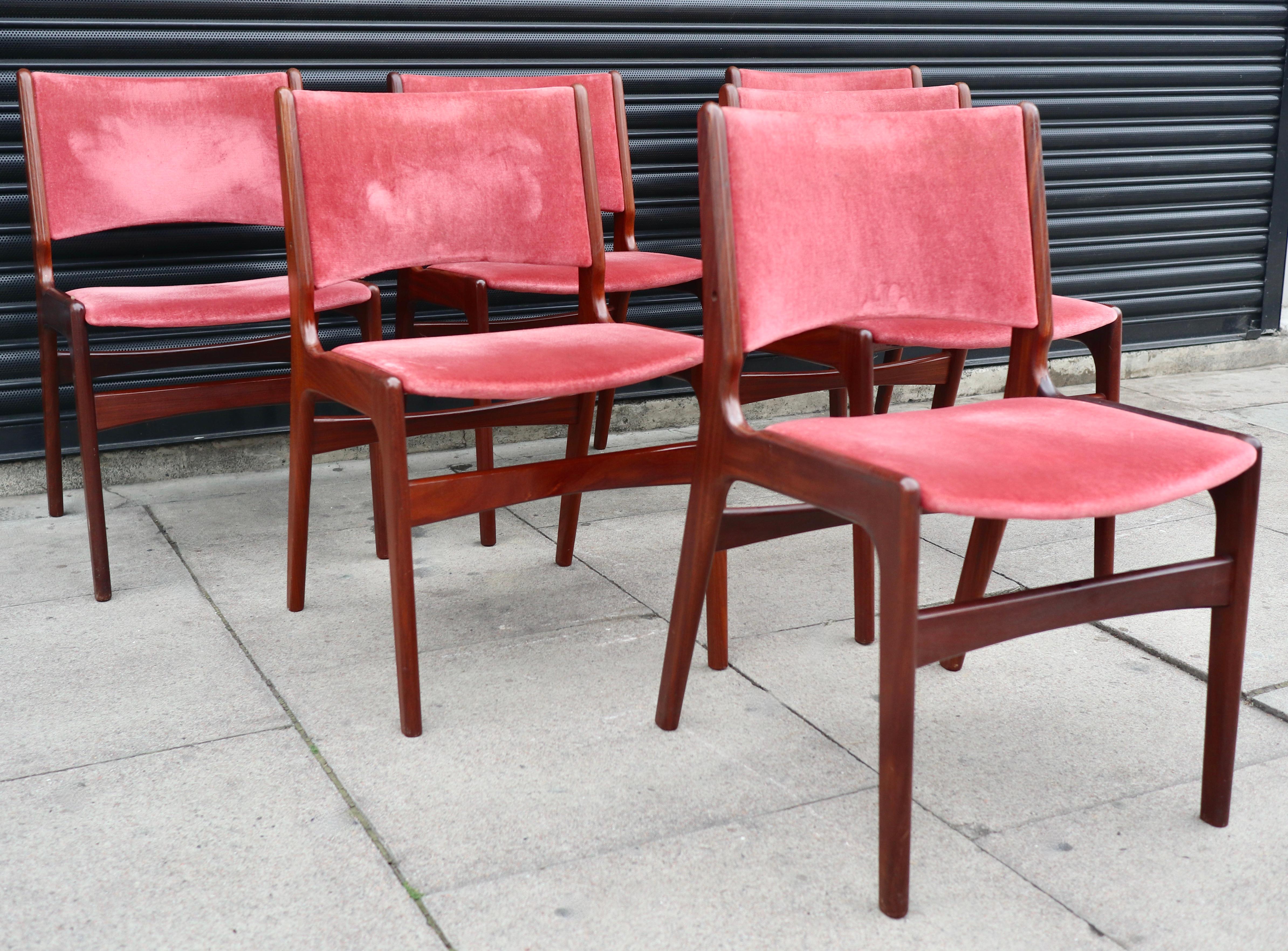 A stylish and rare set of six set of model 89, Danish solid teak framed dining chairs with original pink/red coloured velour textile upholstery.  Designed by Erik Buch for povl Dinesen, these dining chairs feature a curved “floating” seat with a