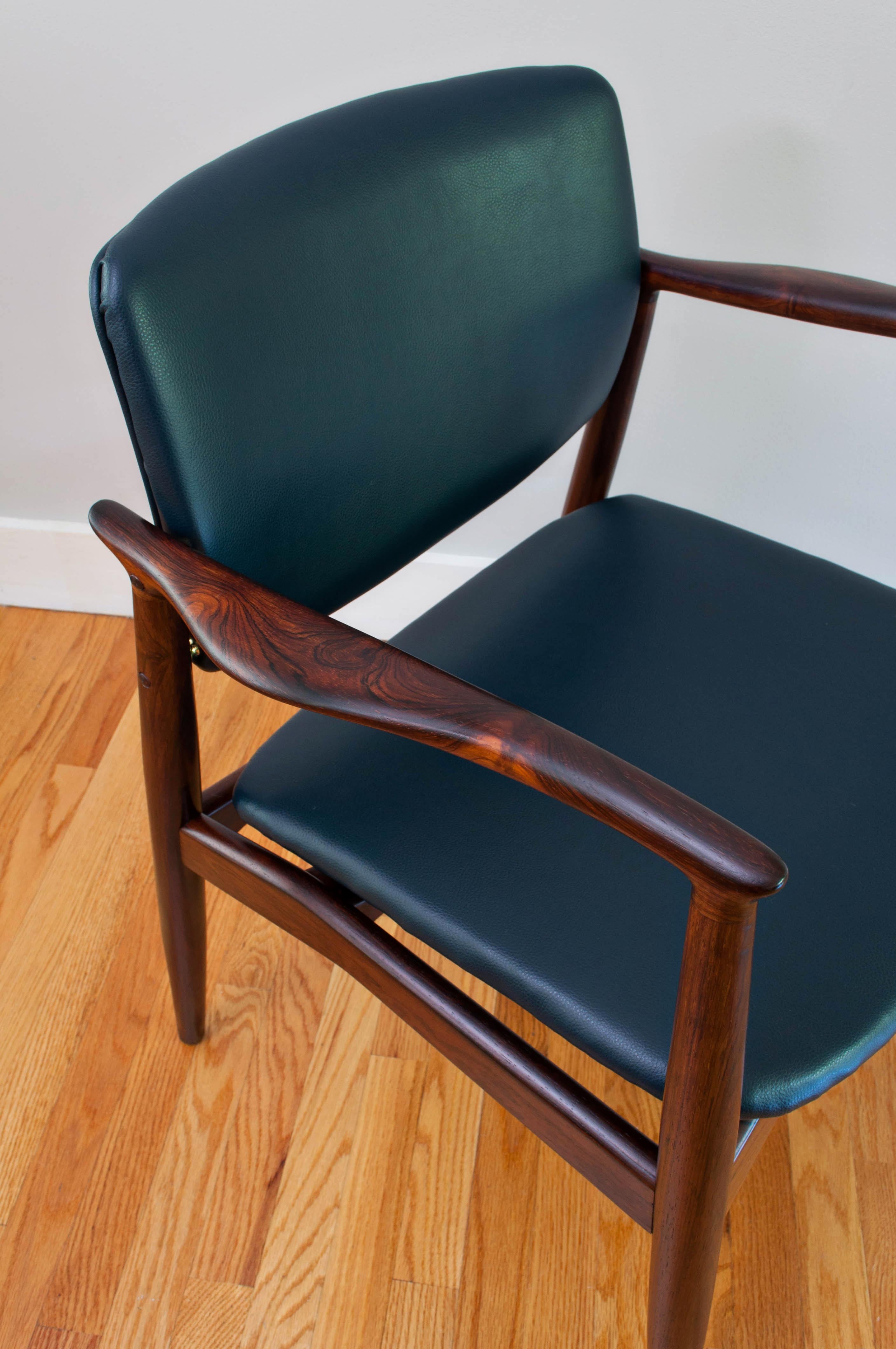 Very seldom seen Brazilian rosewood “Captains Chair” (model SJ 67) by Erik Buch and produced by R. Skovgaard Jensen of Ørum, Denmark. Recently restored with new rich blue faux leather upholstery and revived rosewood.