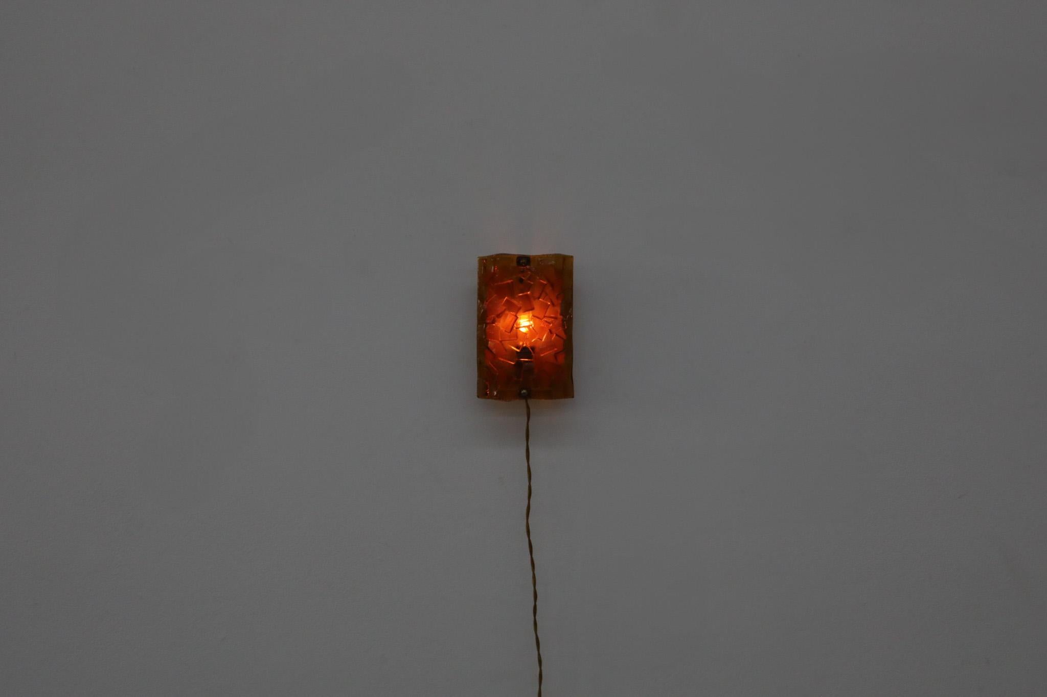 Rare 'Nybro Lampet' orange glass wall sconce with curved molded glass shade for Danish manufacturer Vitrika. This 60's wall sconce has a white enameled metal base and brass accents. In original condition with some age appropriate wear consistent