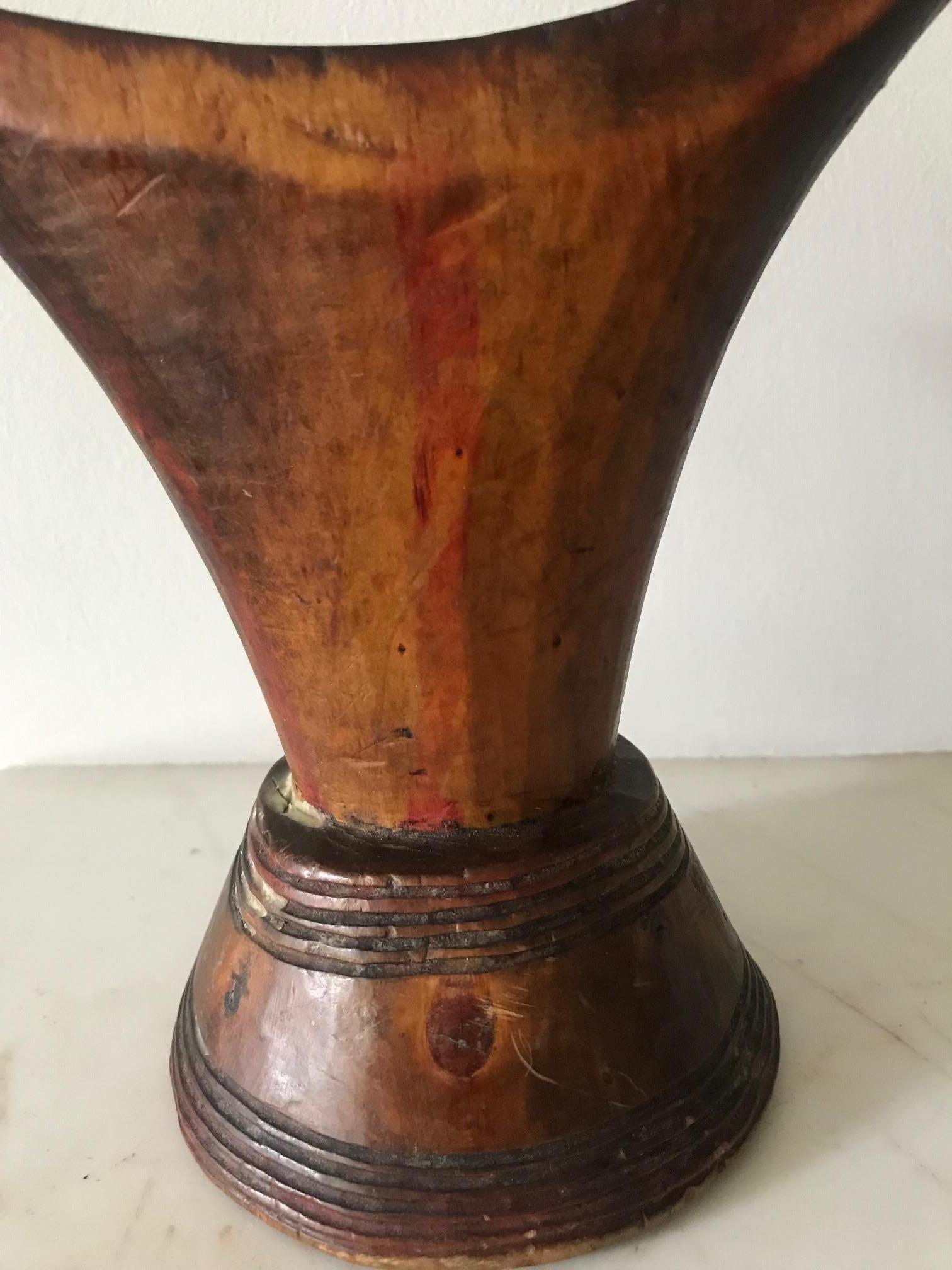 An early to mid-20th century wooden tribal headrest. Good patination with a waxy oiley finish to the top of the headrest. Red paint markings are visible as well as incisions and concentric circles to the base.