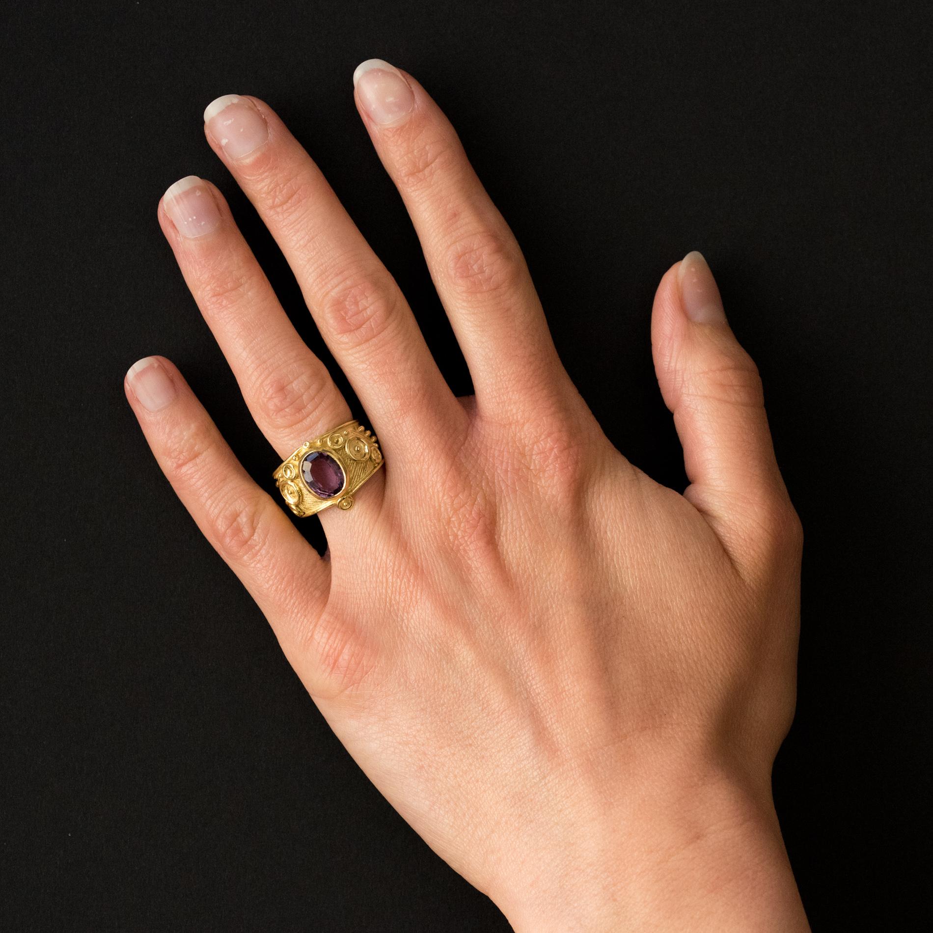 Ring in 18 karats yellow gold.
Inspired by Etruscan jewels, this vintage ring is set with an amethyst. The mount is in amati and chiseled gold.
Weight of amethyst: approximately 1.70 carat.
Height: 1.5 cm, thickness: 0.5 cm.
Width of the ring at the