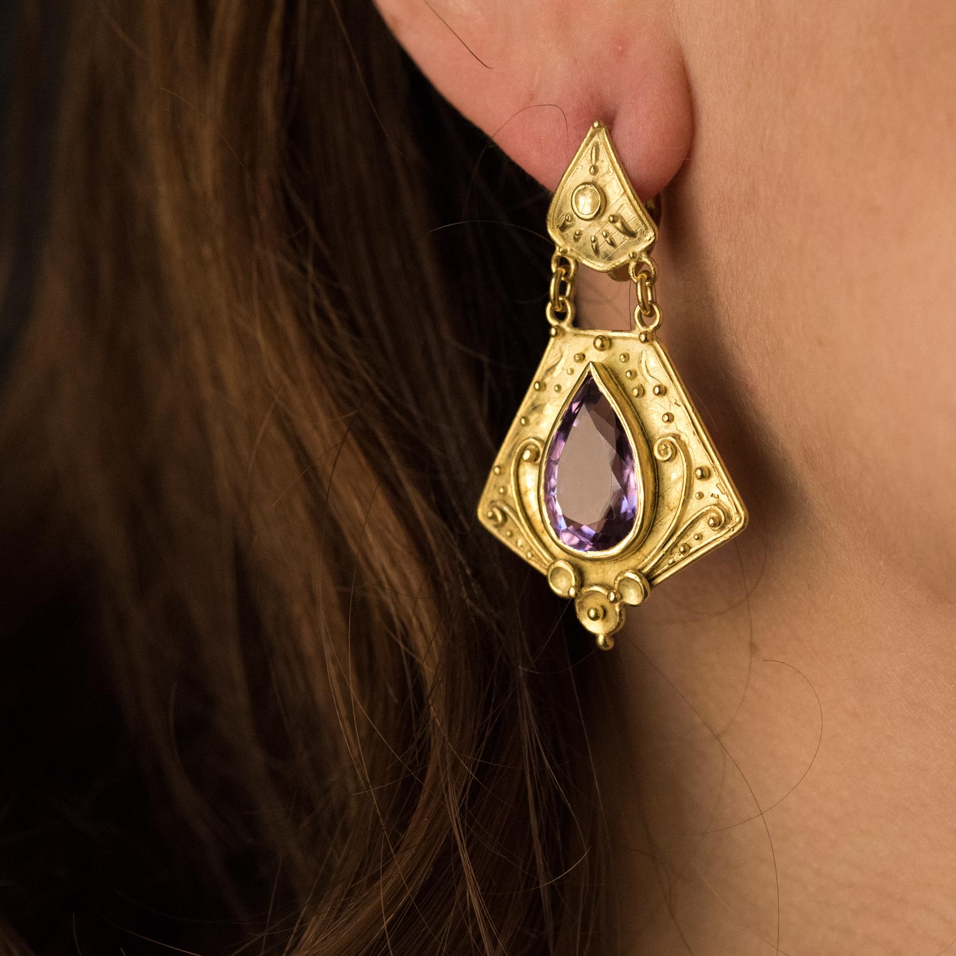 Ohrringe aus 18 Karat Gelbgold.
Diese von etruskischen Schmuckstücken inspirierten Ohrhänger sind mit einem Amethysten im Birnenschliff besetzt, der in eine leicht amatiierte und ziselierte Goldfassung eingefasst ist. Die Schließe ist ein Nagel mit