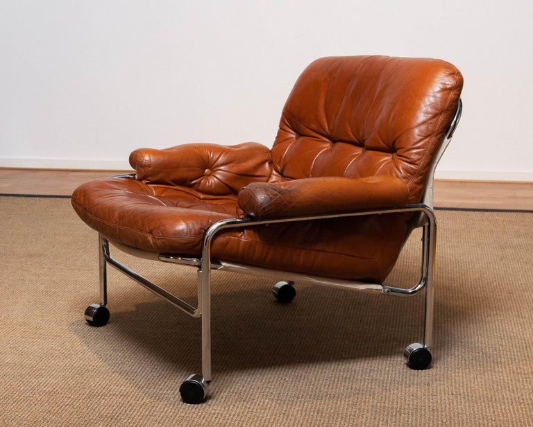Beautiful lounge / easy chair in aged brown / tan leather with great patina and tubular chrome metal tubular frame designed by Pethrus Lindlöfs for A.B. Lindlöfs Möbler Lammhult, Sweden. Model Eva.
The aged leather gives this chair the typical