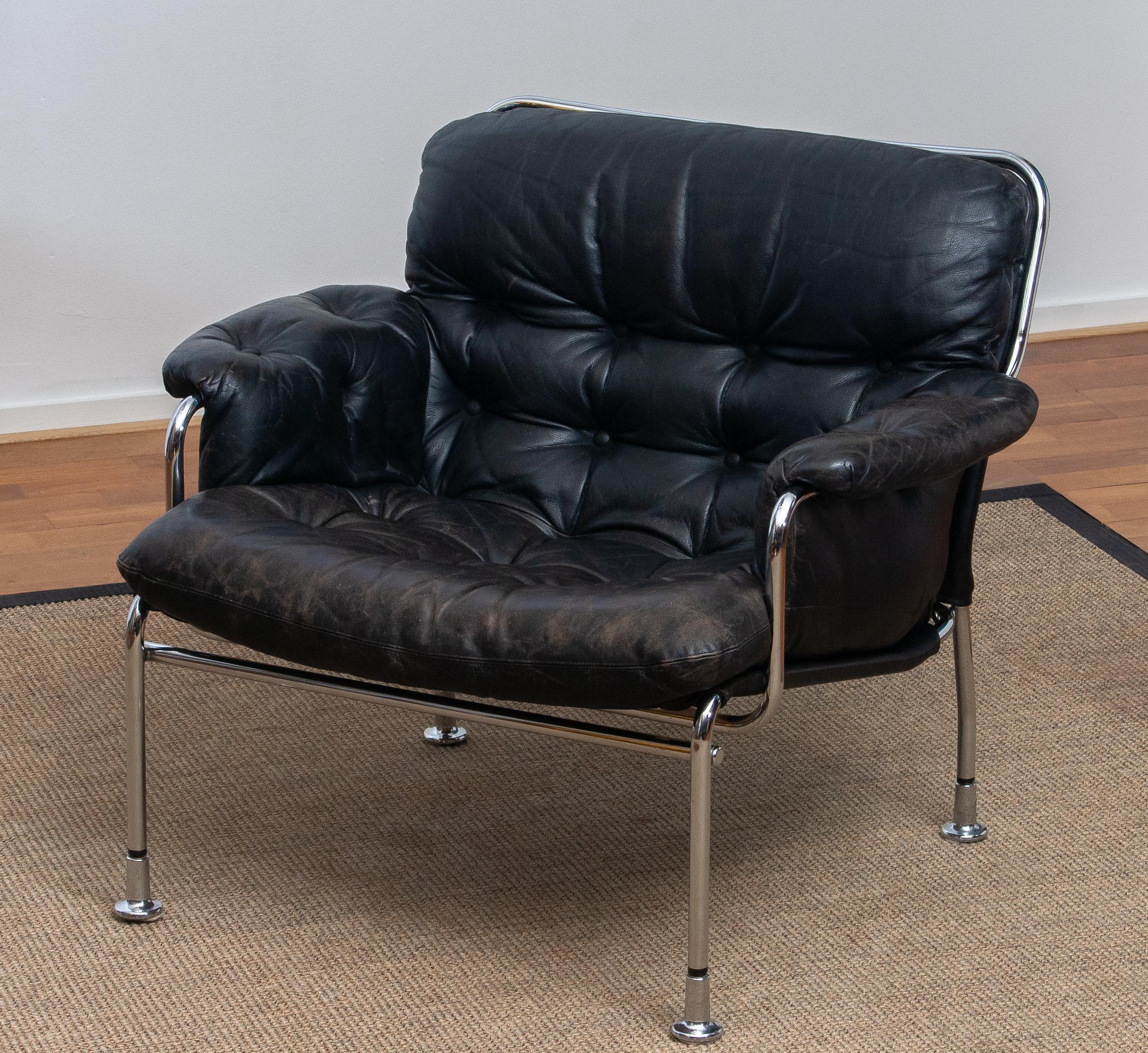 Beautiful lounge / easy chair in aged black leather and tubular chrome metal designed by Pethrus Lindlöfs for A.B. Lindlöfs Möbler Lammhult Sweden. Model Eva.
The aged leather gives this chair the typical vintage character. The leather is soft and