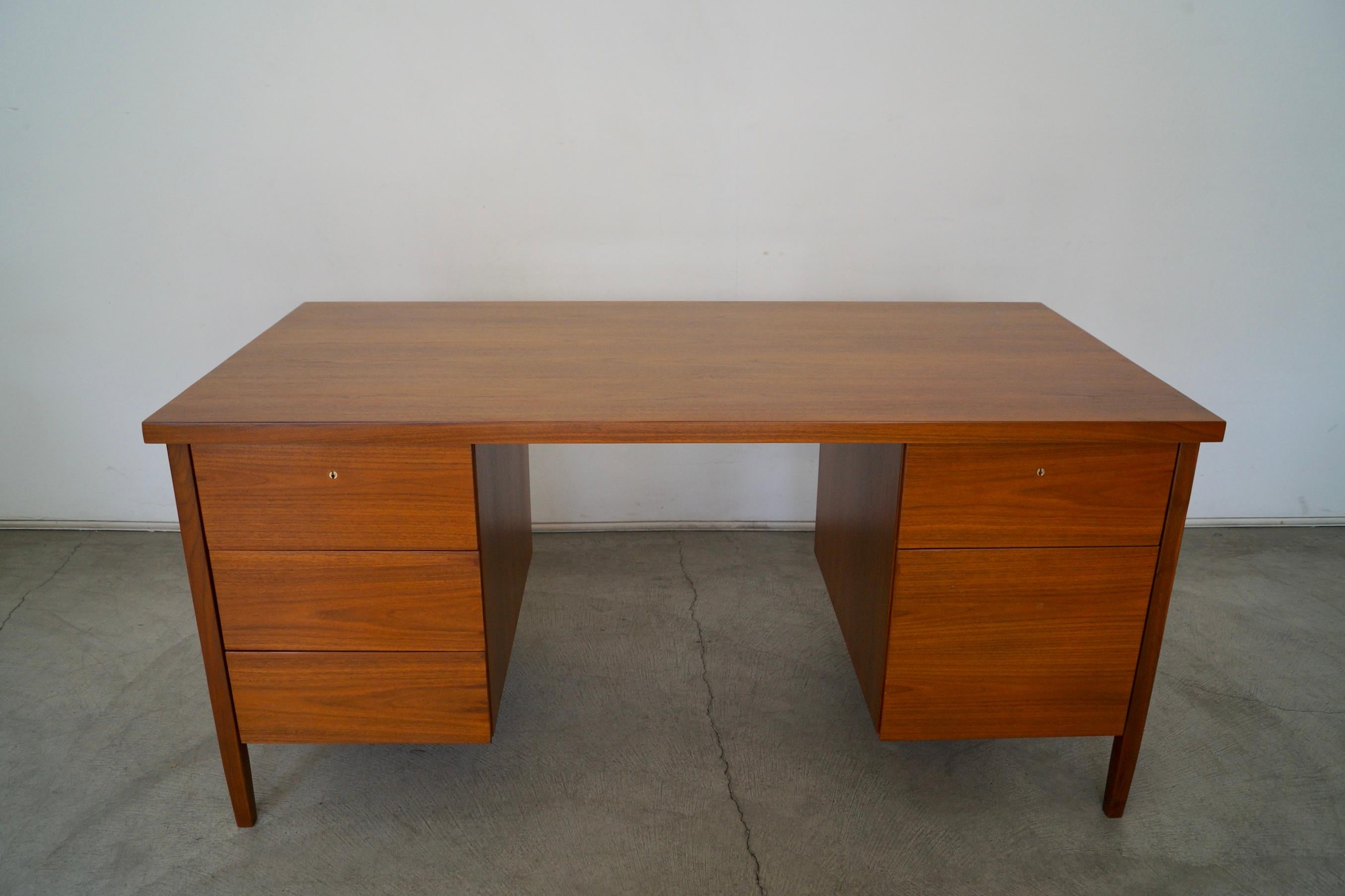 Original vintage Mid-Century Modern executive desk for sale. Designed by Florence Knoll for Knoll, and still has the original vintage 1960s Knoll bowtie label. It has a Classic and clean design, and is made of walnut. It has been professionally