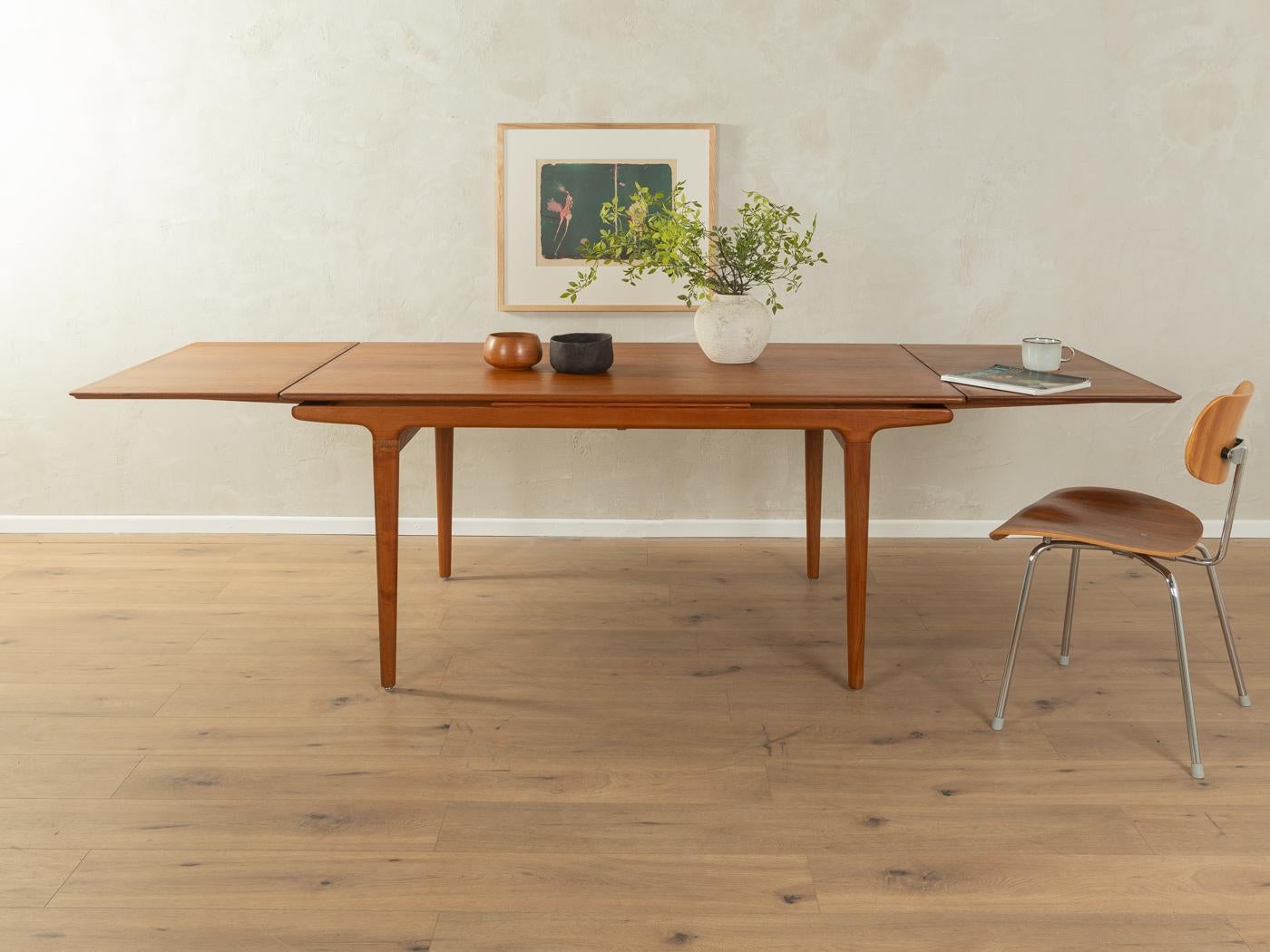 Tavolo da pranzo classico degli anni '60 dal design scandinavo di Johannes Andersen per Uldum Møbelfabrik. Struttura in teak massiccio e piano del tavolo impiallacciato con bordo in legno massiccio. 

Caratteristiche di qualità:
design accurato: