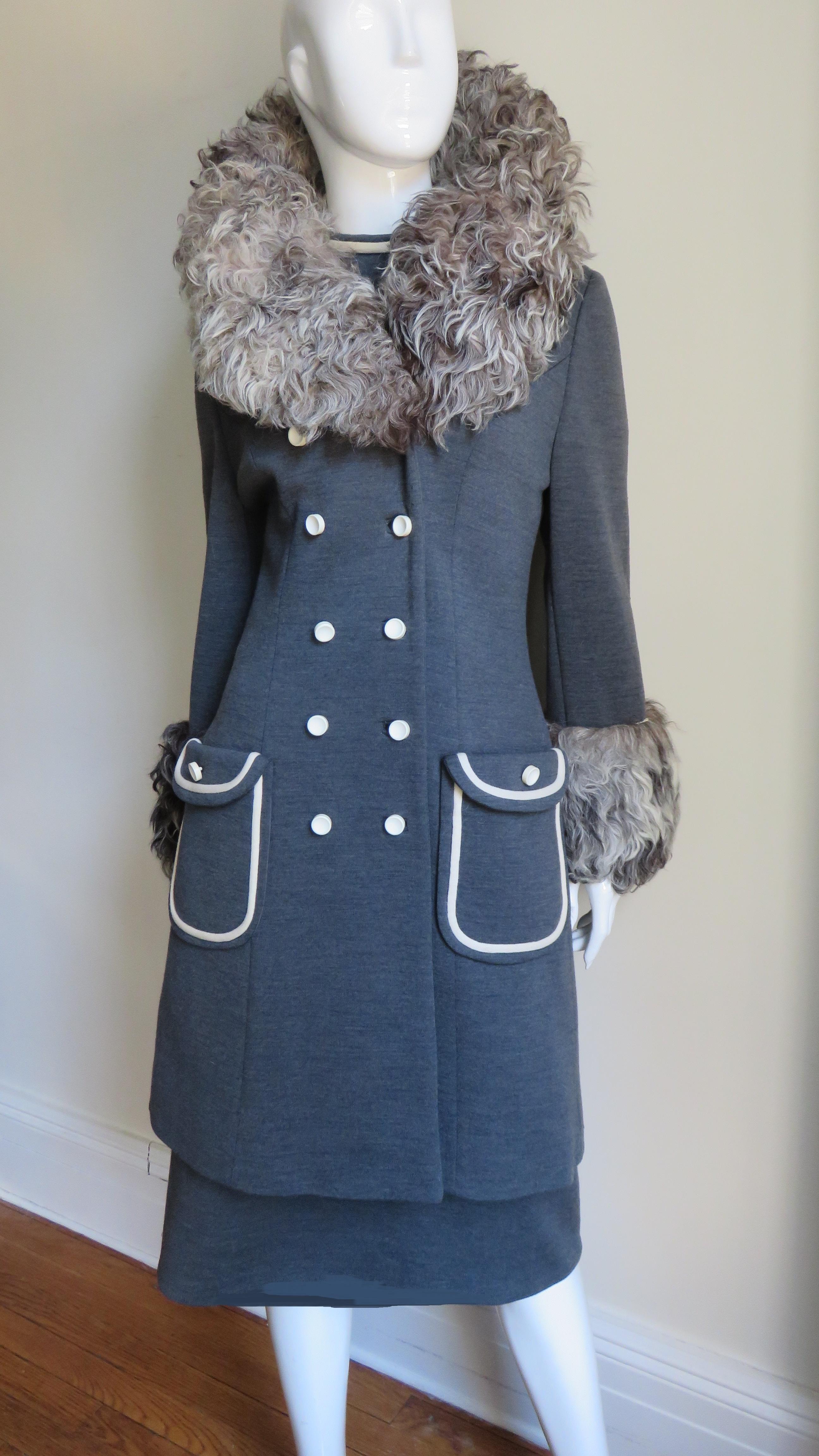 A gorgeous coat and dress set in a charcoal grey wool knit by Lilli Ann.   Swaths of off white and shades of grey Mongolian Lamb fur adorn the coat collar and cuffs.  The short sleeve dress has a waist seam, stand up collar and 2 pocket flaps all