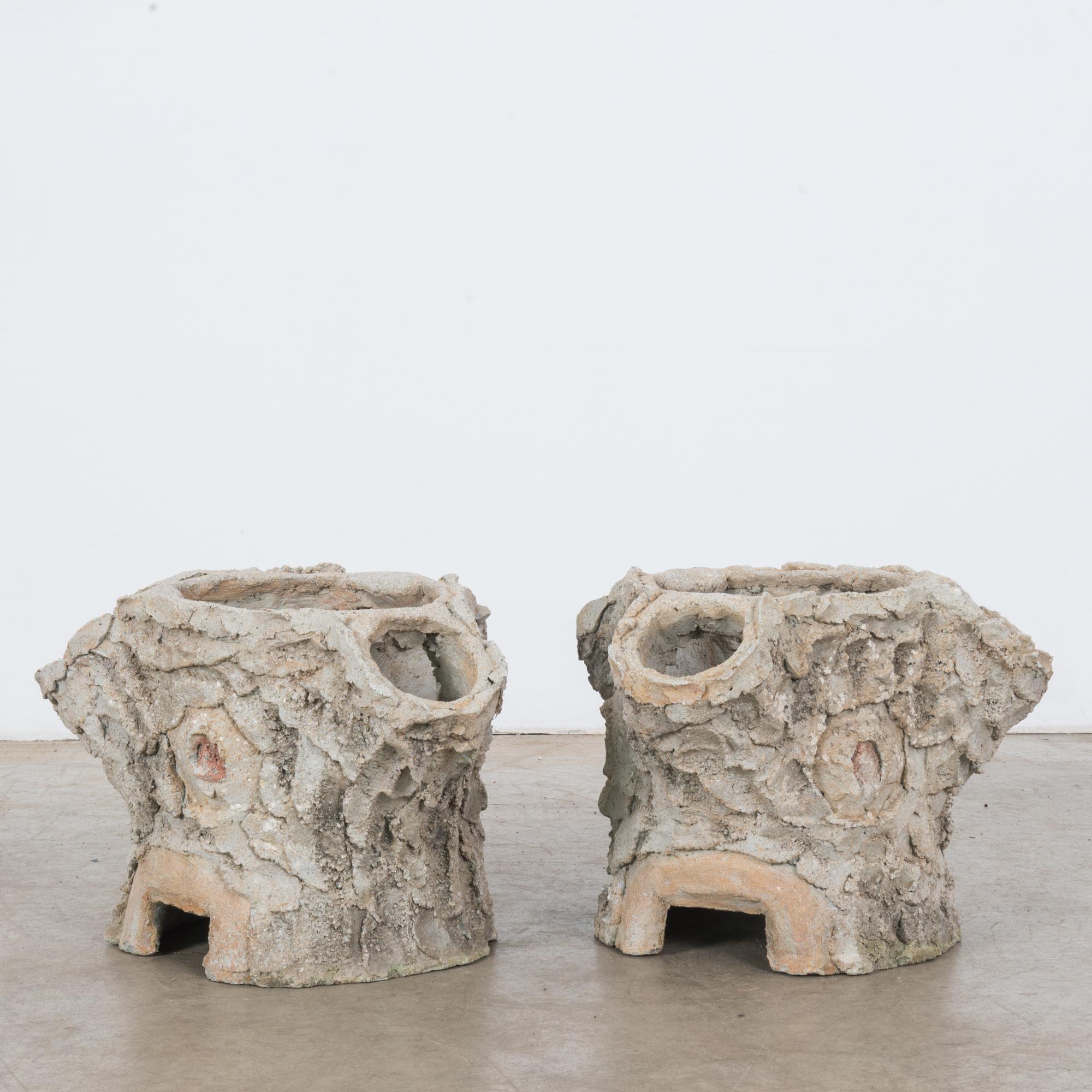 A pair of faux bois concrete planters from France, circa 1960. The form is organic, reminiscent of tree stumps. The rugged, textural application of concrete to the outer surface gives the impression of tree bark. Lively, rustic and nature-inspired,