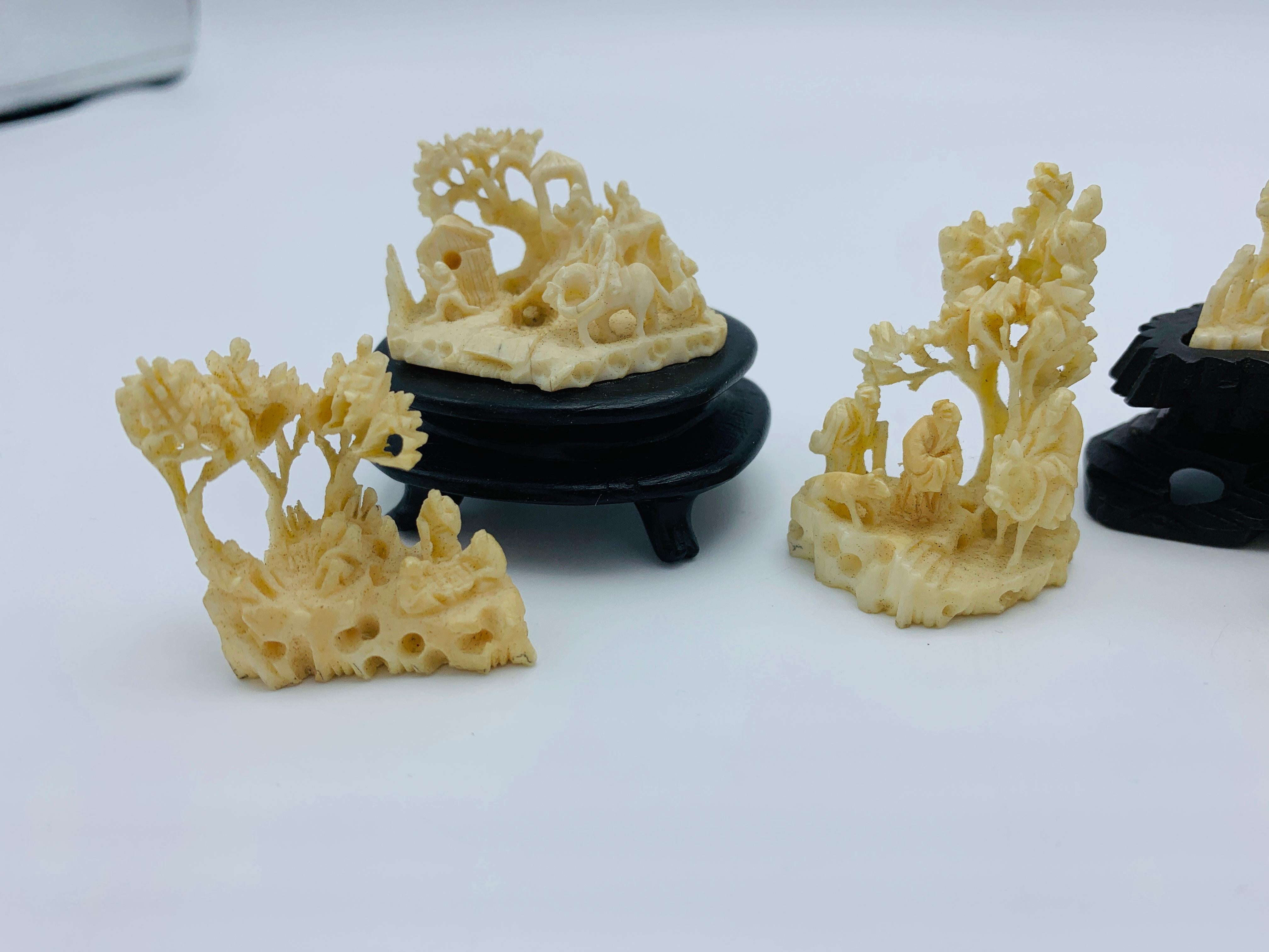 Listed is an absolutely stunning, set of nine, 1960s faux ivory resin sculptures. This miniature set includes nine carved sculptures of ornate scenes of pagodas, figures, bonsai trees, and other ornate foliage. Set includes three stands, perfectly