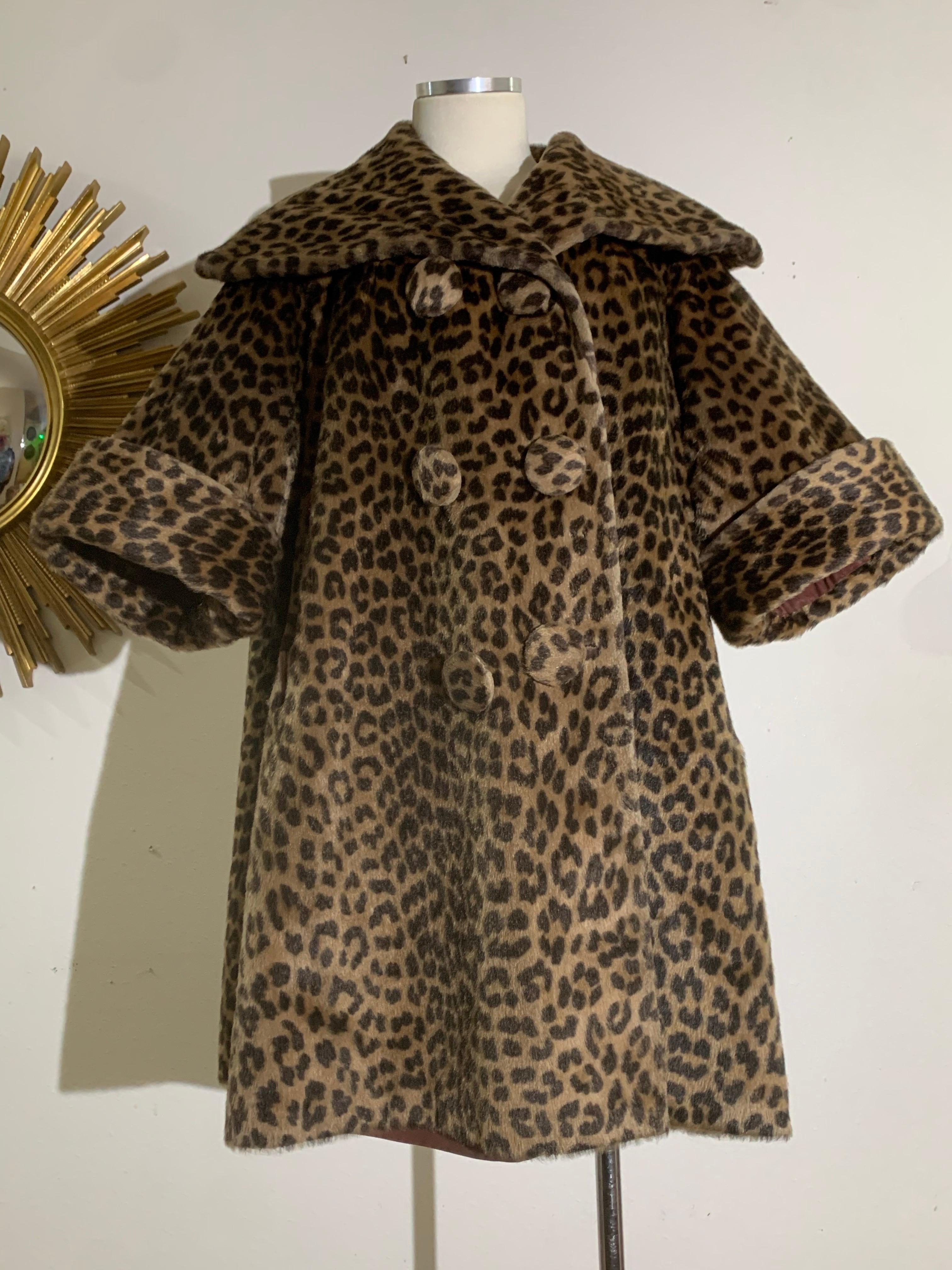 Cappotto swing stile principessa leopardato finto degli anni '60 con collo a scialle e maniche a polsino: Un lussuoso cappotto in finto leopardo con corpo voluminoso, ampio collo a scialle, maniche a bracciale risvoltate e grandi bottoni coperti.