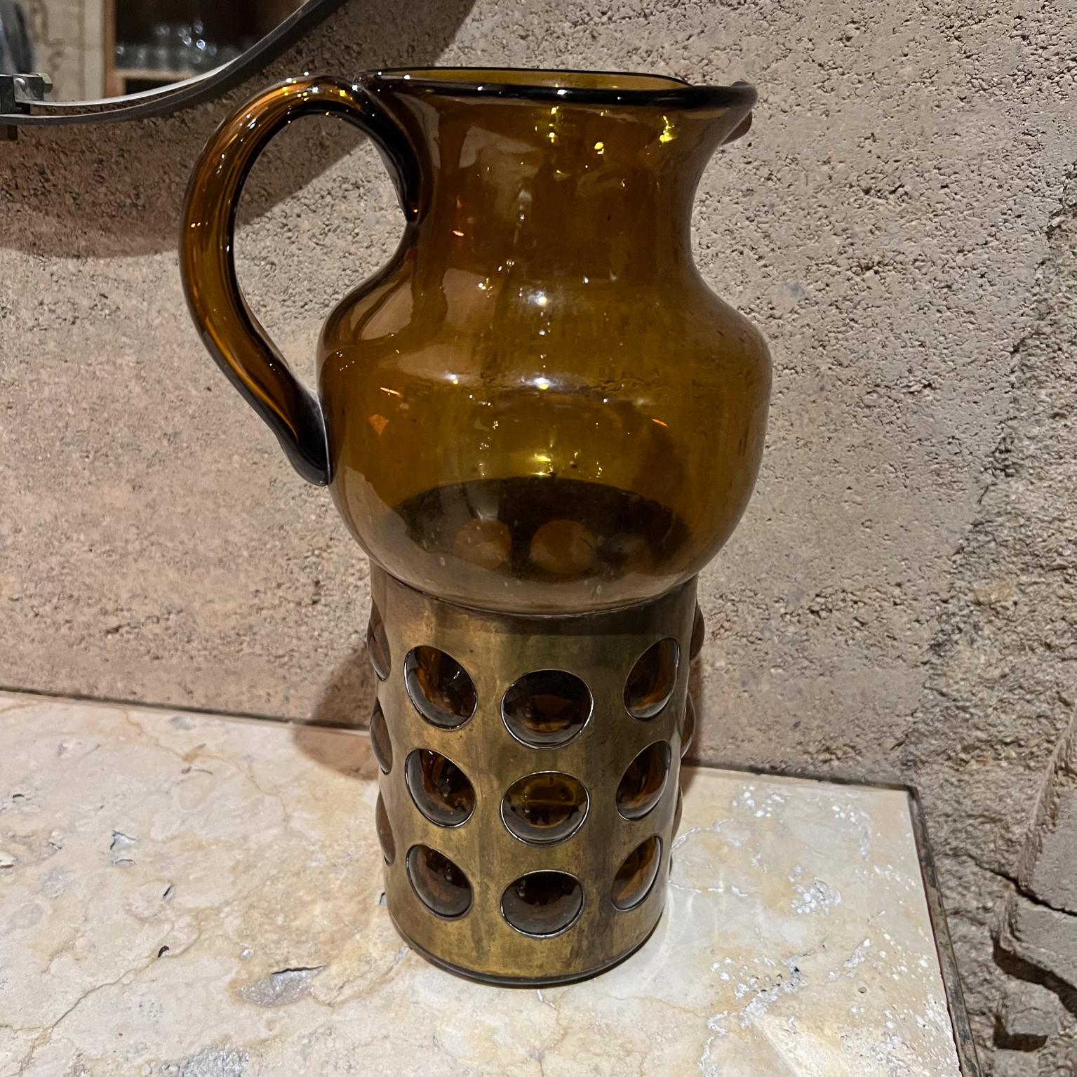 AMBIANIC presents
1960s Feders Felipe Delfinger Handblown Amber Caged Art Glass Pitcher Mexico
12 h x 6 diameter x 7.5 d
Preowned original good vintage condition.
Ready for use!
Refer to all images.