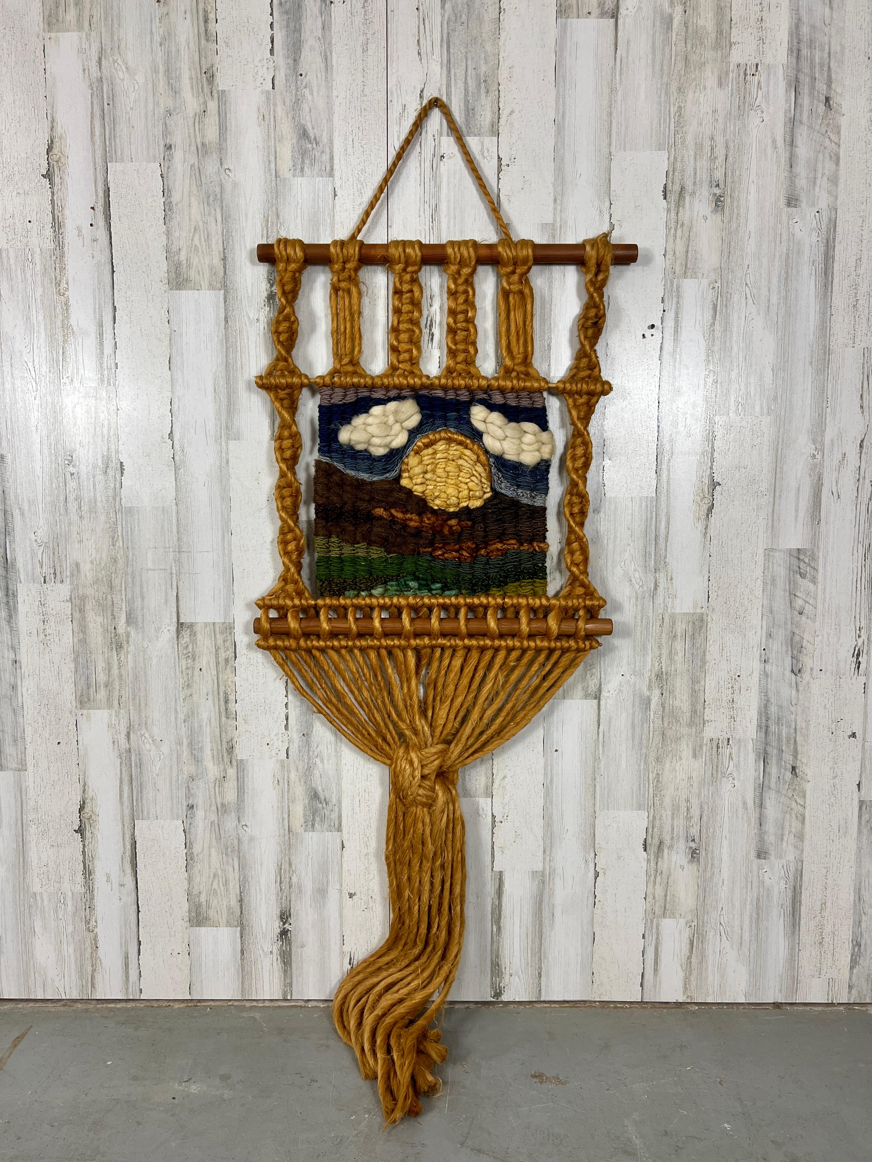 Large Macrame handcrafted with many different knot styles and a scene of hills, sun and clouds.
