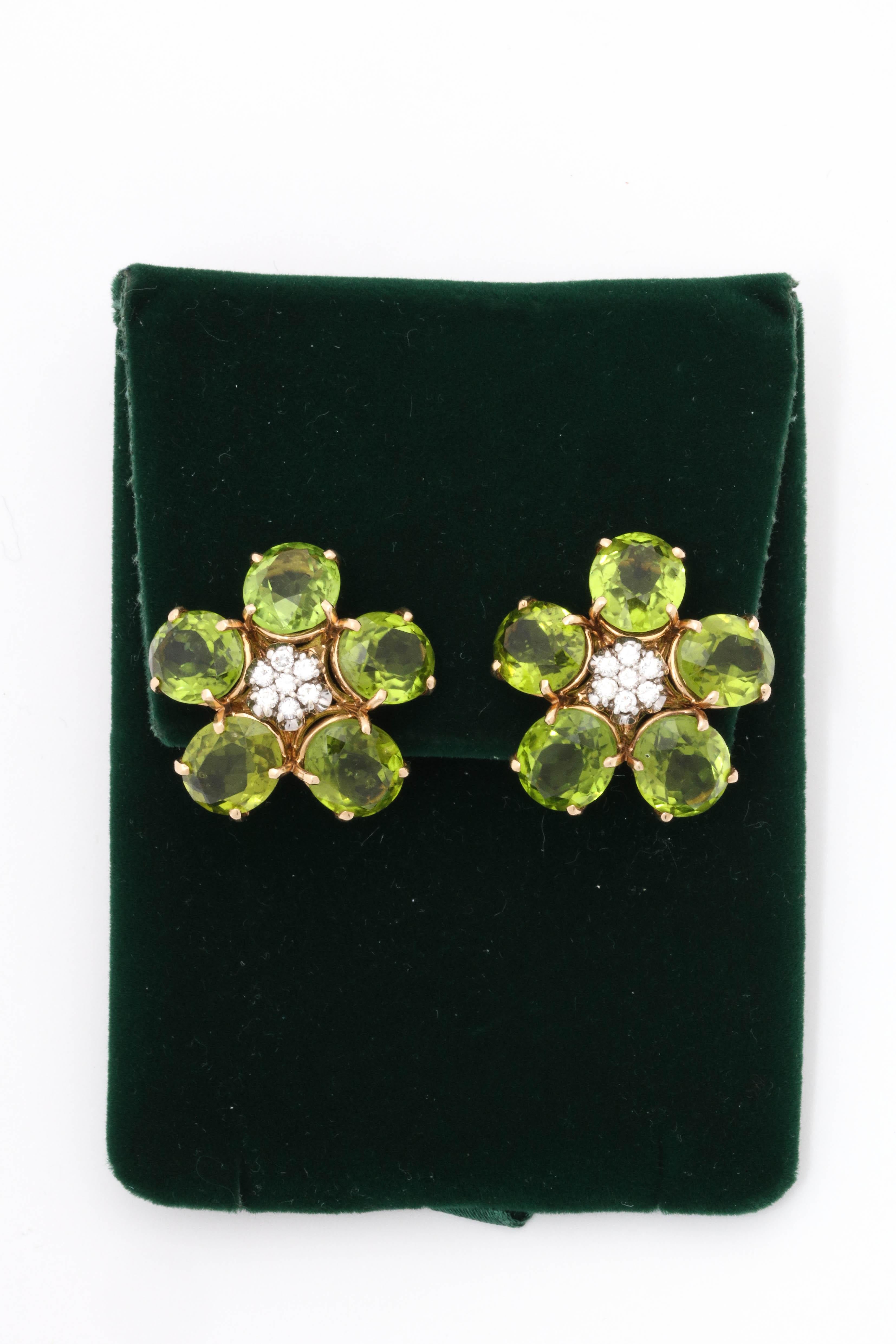 One Pair Of Ladies 18kt Yellow Gold Earclips Designed With Ten Large Peridot Stones Weighing Approximately 50 Carats Total Weight. Earrings Are Further Embellished With Two Diamond Cluster Centers Weighing Approximately 1 Carat Total weight. NOTE:
