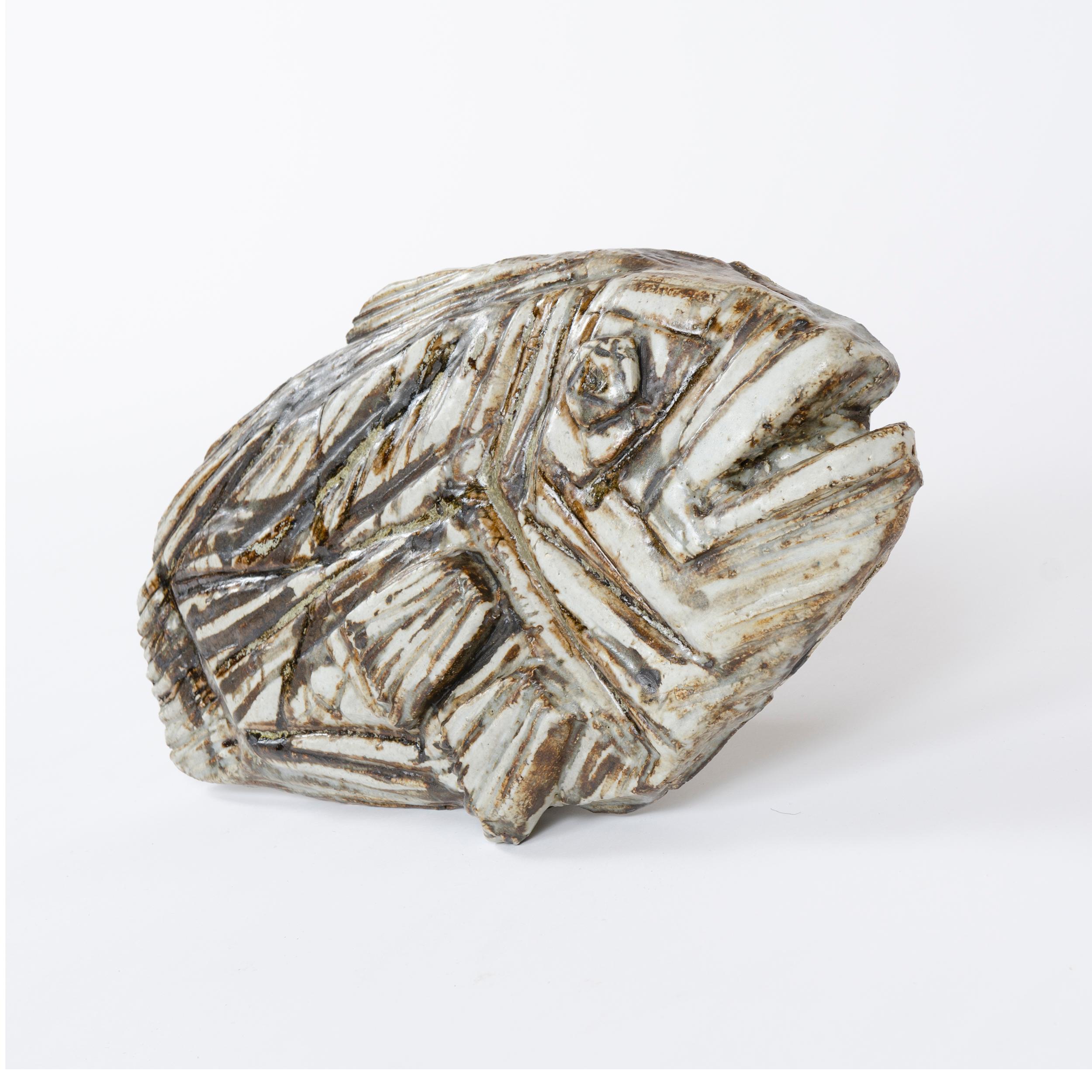 A substantial stoneware sculpture of a fossilized flatfish having a rich and variegated matte glaze over expressive textural impressions enriched by brown underglaze markings. Signed and stamped.