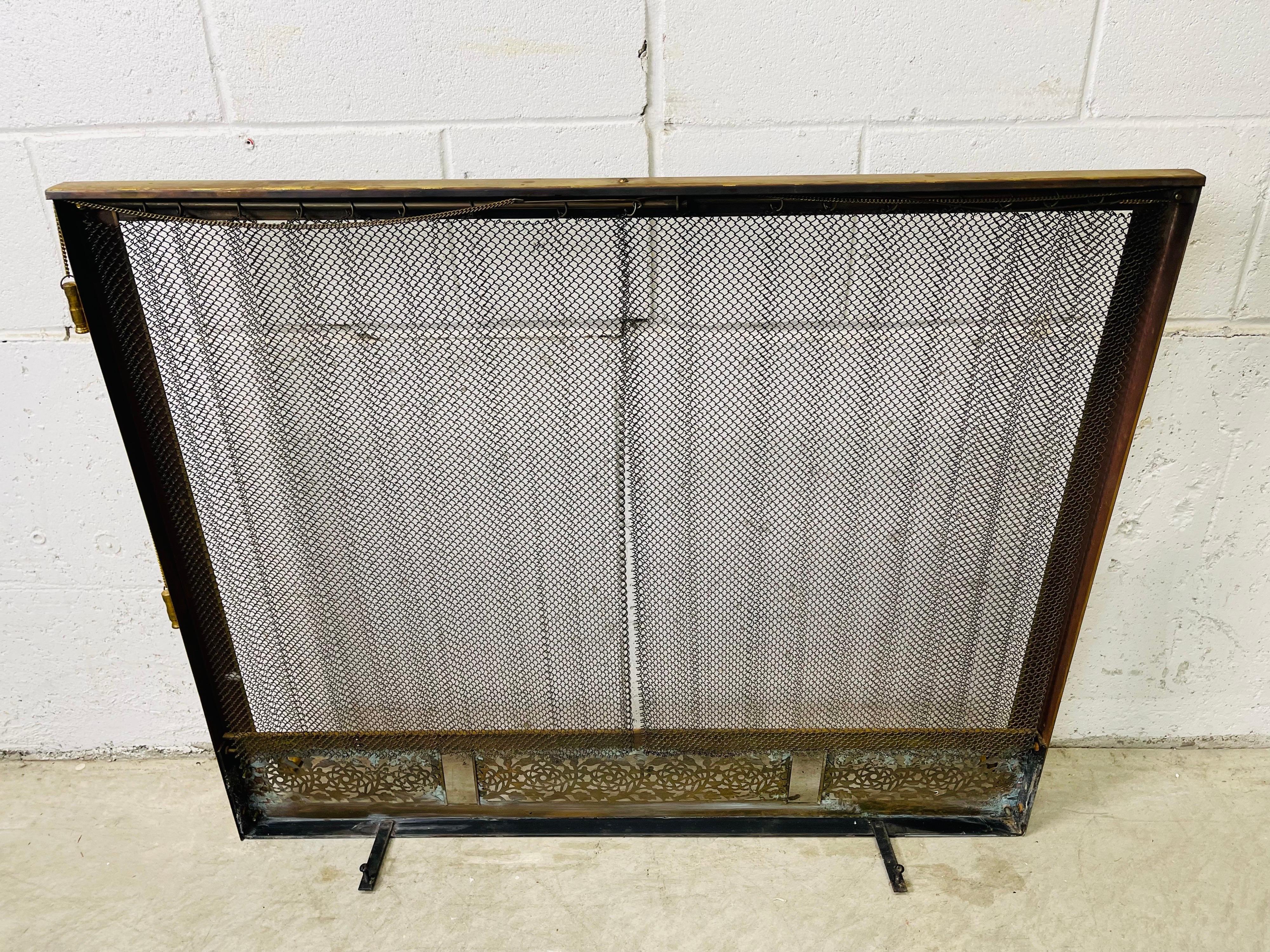 Vintage 1960s brass fireplace screen with matching andirons set. Screen doors work and the set has matching feet. Tarnish from age and use. Andirons measure: 8.5”L x 15”D x 15.75”H. No marks.