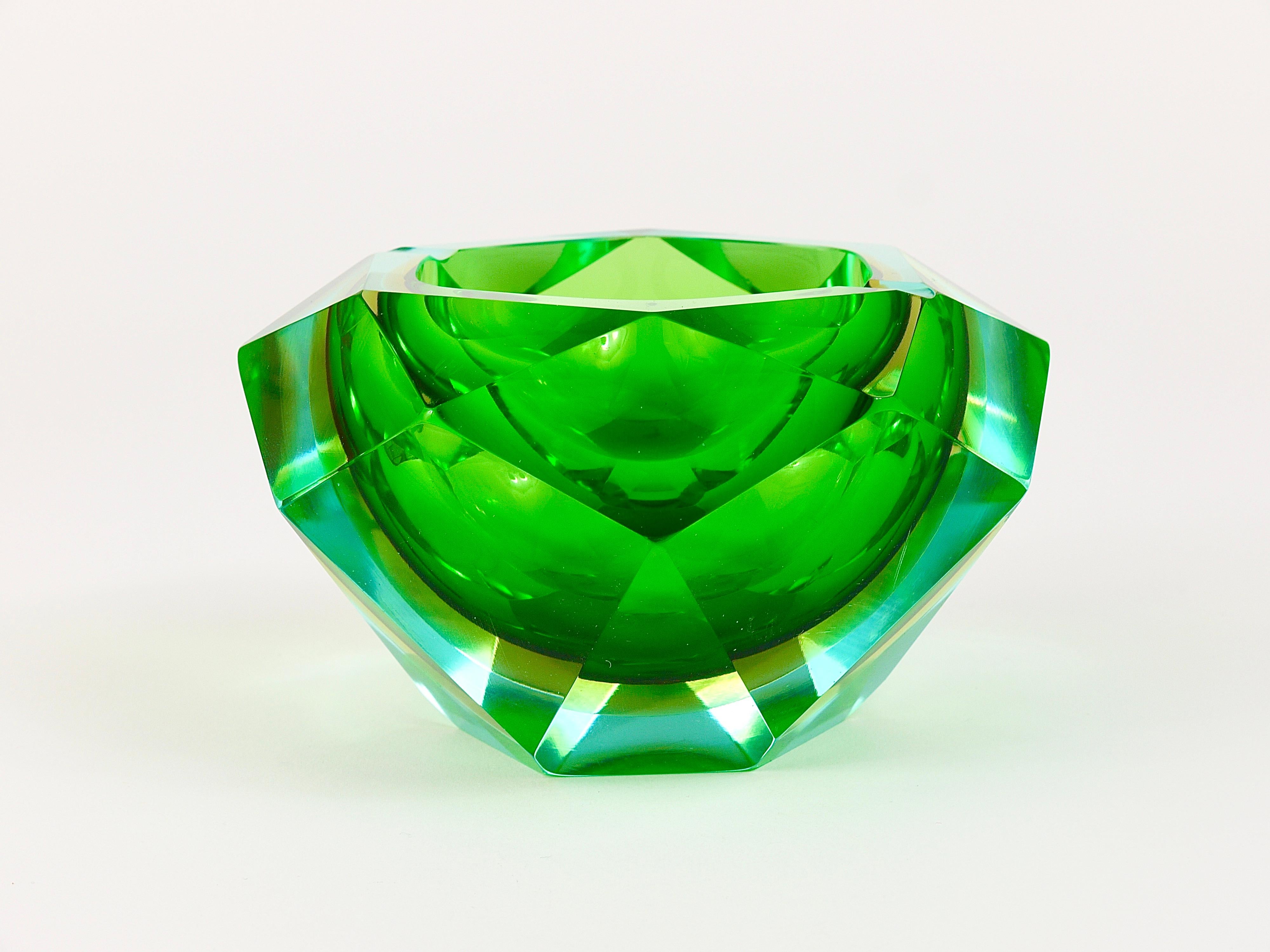 A beautiful multi-faceted and polished Murano glass ashtray in a wonderful diamond shape from the 1960s. Designed by Flavio Poli for Seguso Vetri d'Arte, Italy. A colorful combination of light-blue, yellow and green layered art glass. In very good