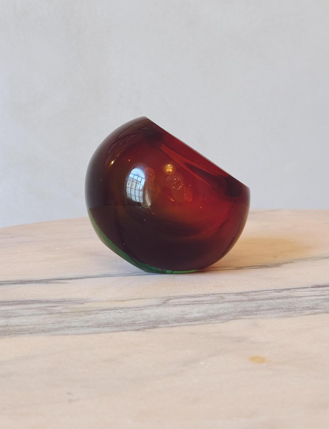 A large hand-blown Murano glass 'sommerso' (submerged hand-blown glass) spherical bowl. This stunning piece has a dark red core and green surround. It sits on a flat base at an angle and can be used purely as decoration or 'tasca vuota' (literally