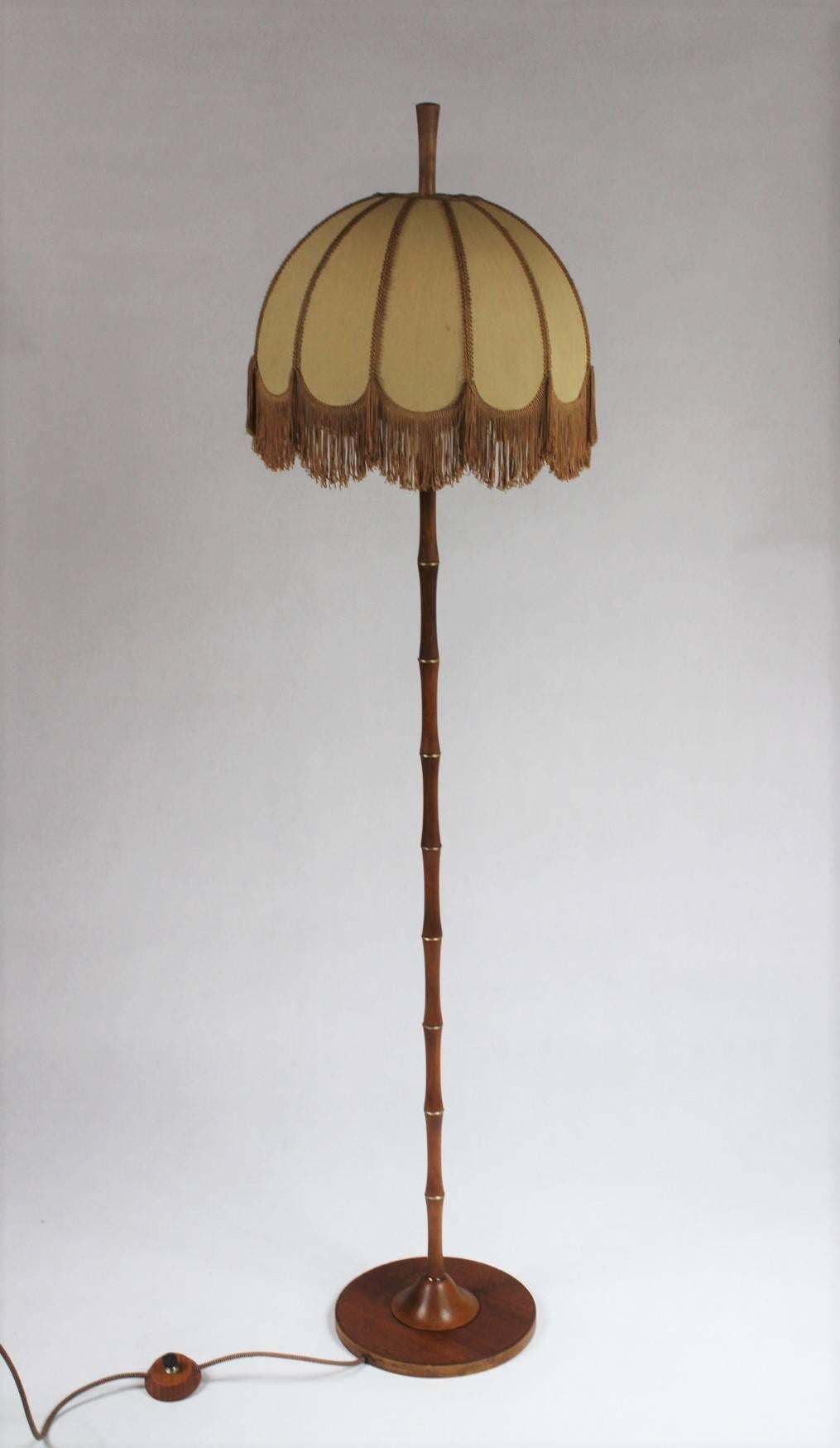 Swedish floor lamp from the 1960s, labeled Zenith. Mahogany base, cherrywood and fabric. The lamp has been restored.
