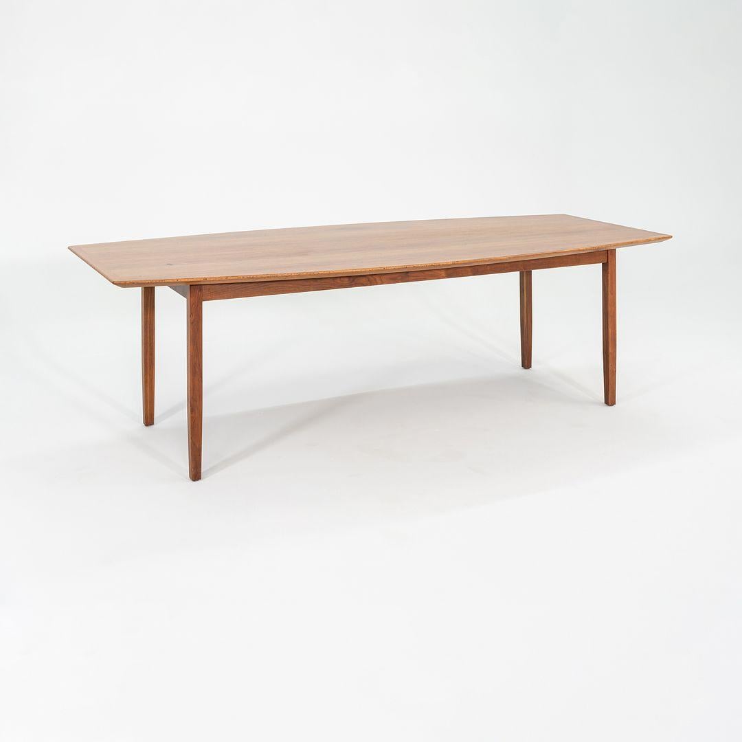 Il s'agit d'une table de conférence ou de salle à manger en noyer, conçue par Florence Knoll et produite par Knoll aux États-Unis dans les années 1960. Il a un peu la forme d'une planche de surf (également appelée forme de bateau), mais il est